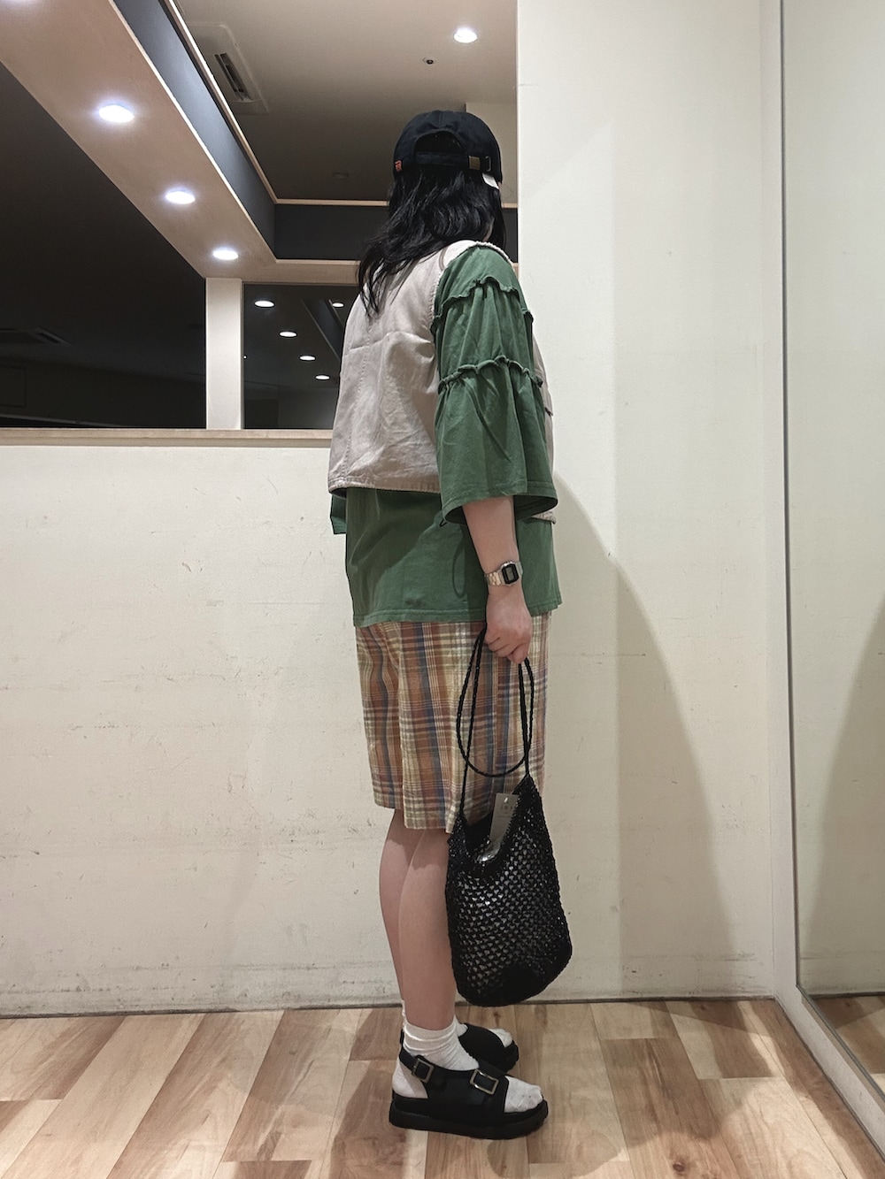 オレンジ系のその他パンツ、グリーン系のTシャツ/カットソー、グレー系のベストを着用したレディースの春コーディネートの2枚目の写真