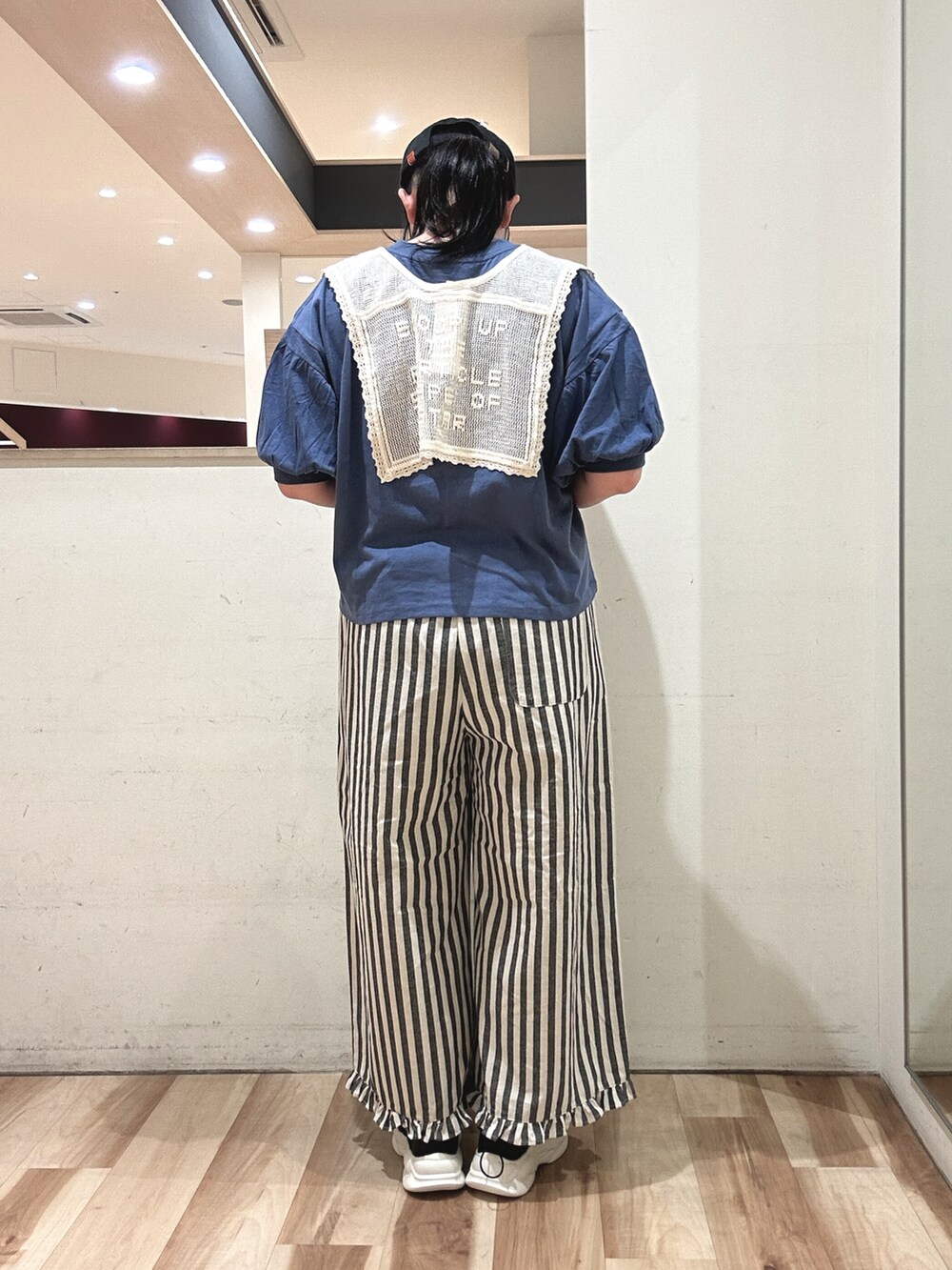 ブルー系のTシャツ/カットソー、ブラック系のスニーカー、ベージュ系のその他パンツを着用したレディースの春コーディネートの3枚目の写真