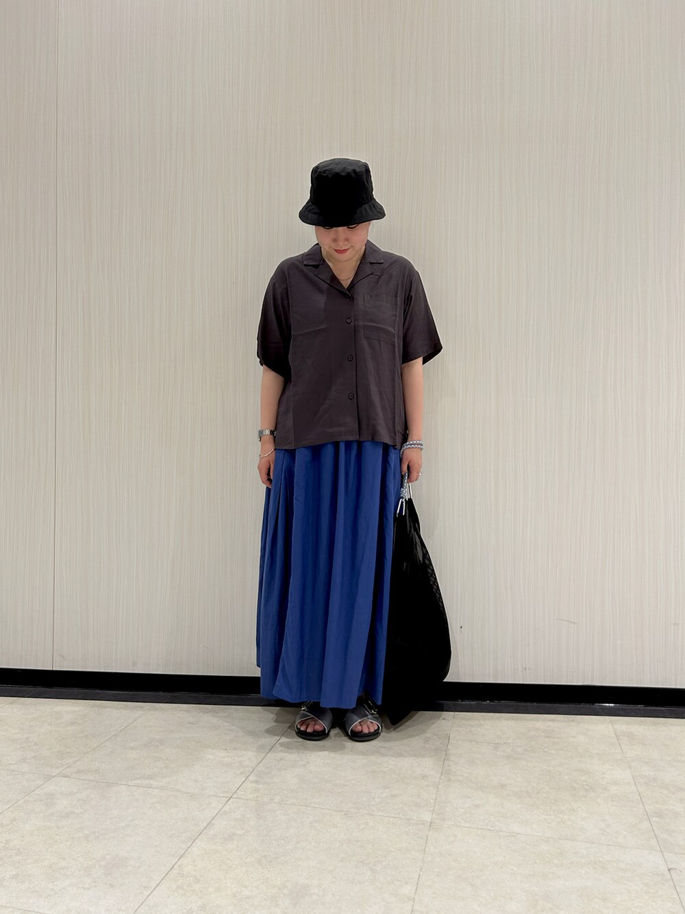 グレー系のシャツ/ブラウス、ブラック系のハンドバッグ、ブルー系のスカートを着用したレディースの夏コーディネートの2枚目の写真