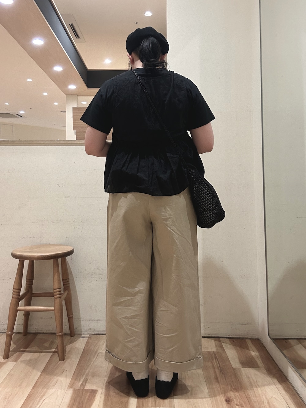 ブラック系のハンドバッグ、ブラック系のベスト、ブラック系のTシャツ/カットソーを着用したレディースの春コーディネートの3枚目の写真