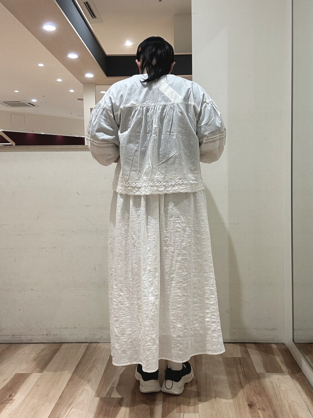 ブラック系のハンドバッグ、ブラック系のスニーカー、ホワイト系のシャツ/ブラウスを着用したレディースの春コーディネートの3枚目の写真