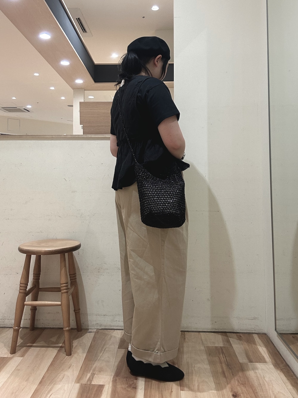 ブラック系のハンドバッグ、ブラック系のベスト、ブラック系のTシャツ/カットソーを着用したレディースの春コーディネートの2枚目の写真