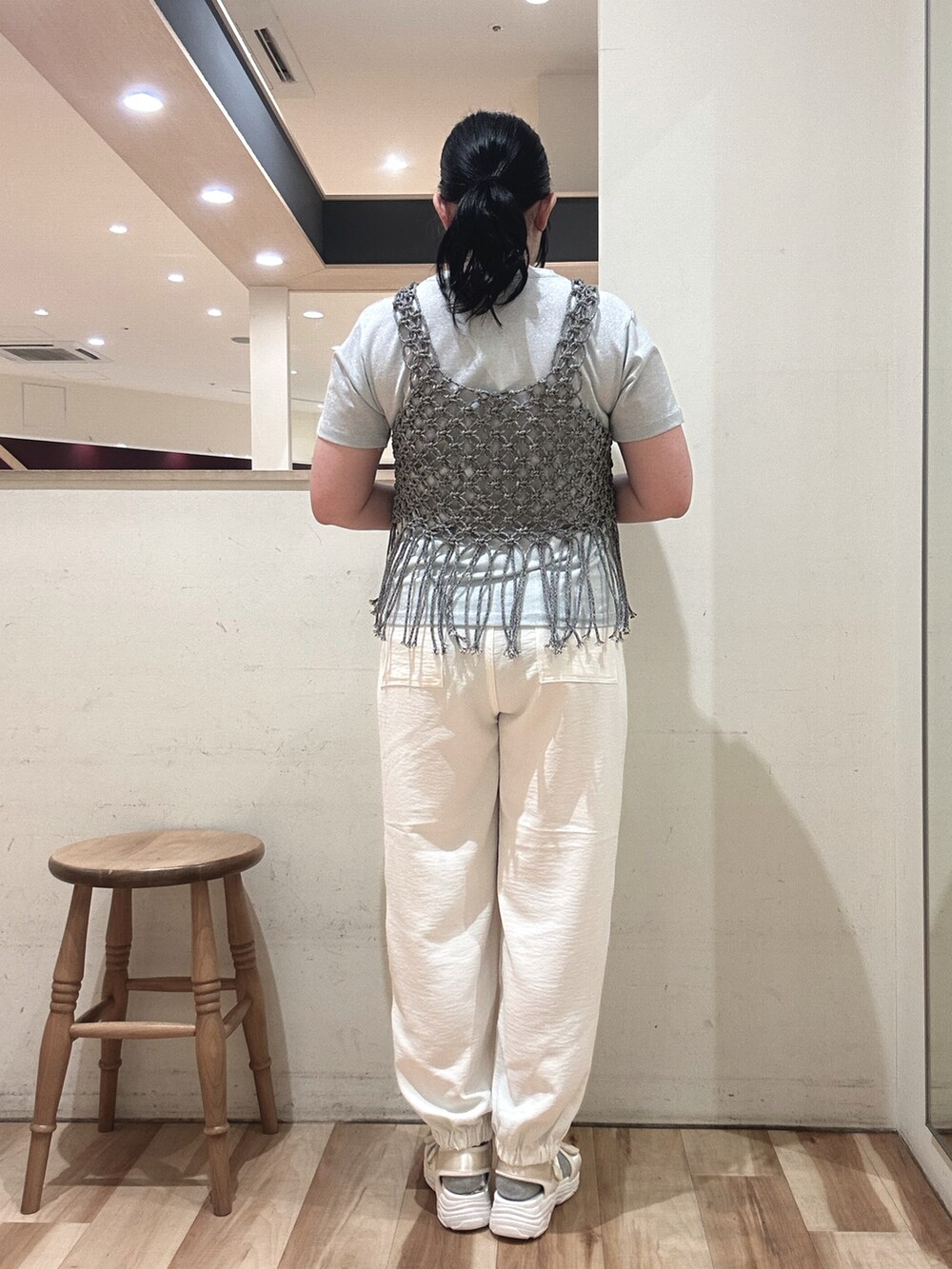 ホワイト系のハンドバッグ、グレー系のベスト、ブルー系のTシャツ/カットソーを着用したレディースの春コーディネートの3枚目の写真