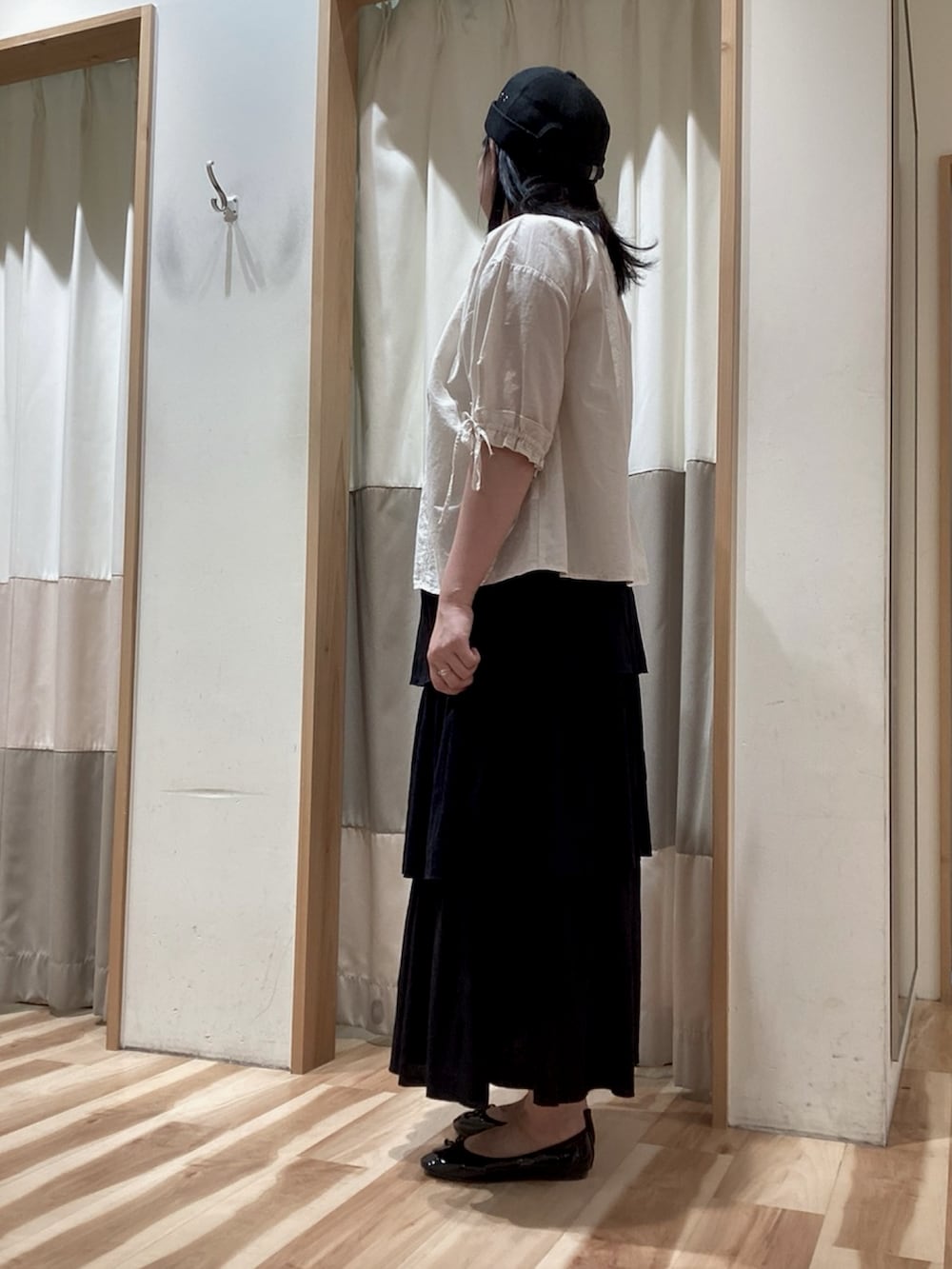 ブラック系のスカート、ホワイト系のシャツ/ブラウス、ブラック系のパンプスを着用したレディースの夏コーディネートの3枚目の写真