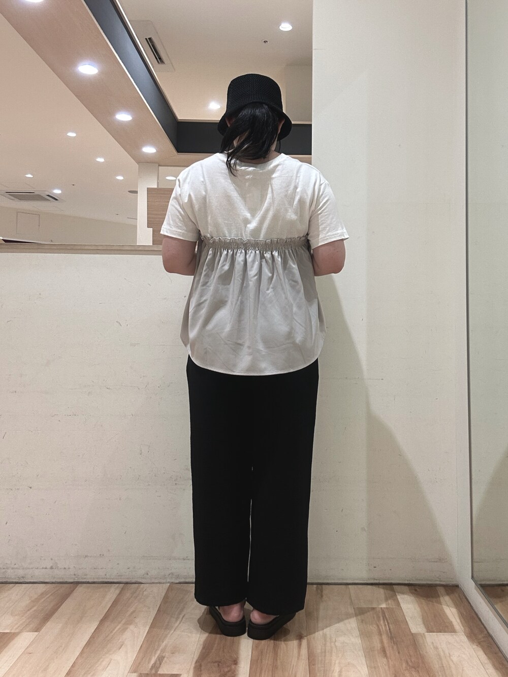 グレー系のTシャツ/カットソー、ブラック系のハンドバッグ、ベージュ系のドレスシューズを着用したレディースの春コーディネートの3枚目の写真