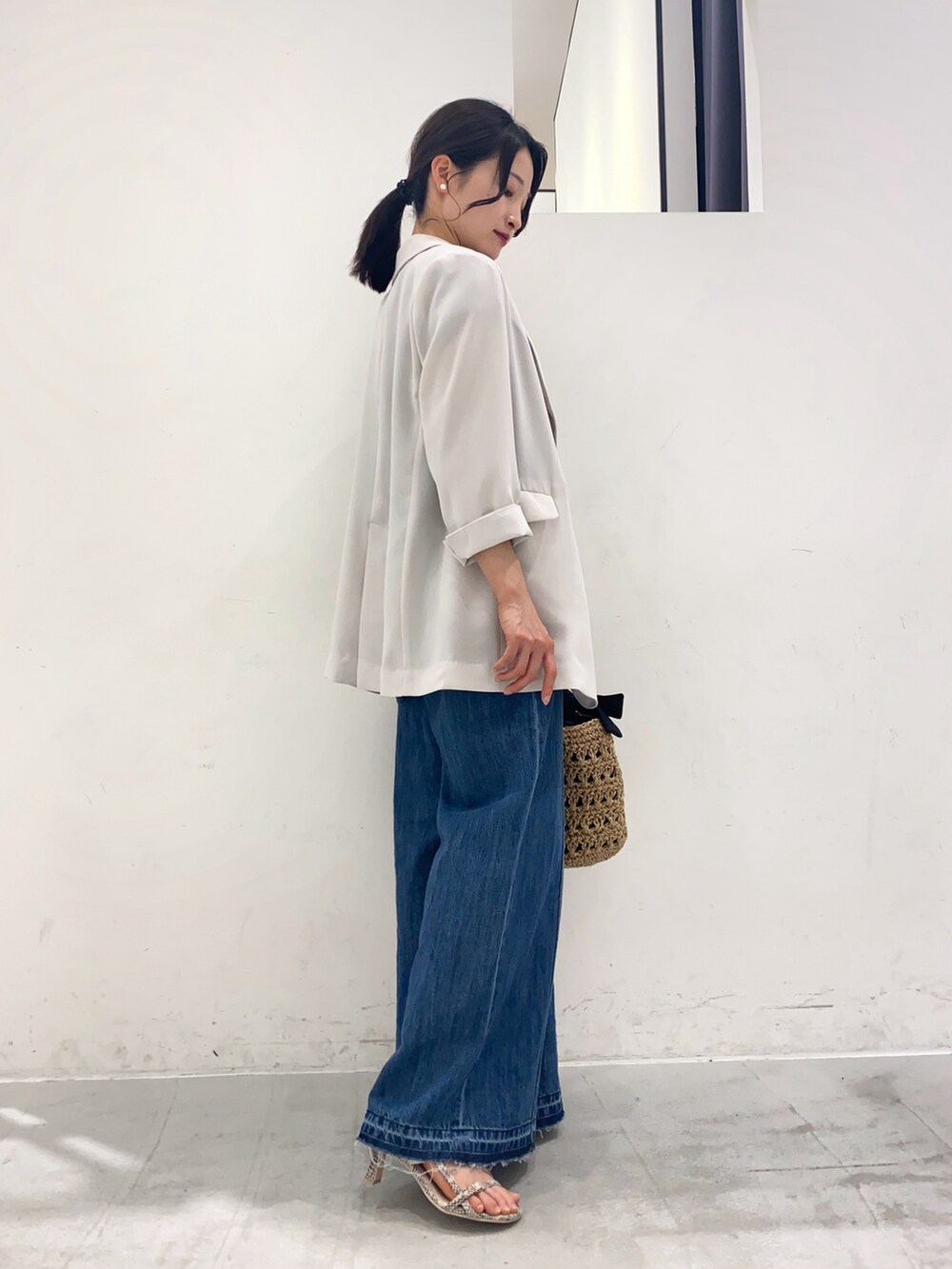 ブラック系のTシャツ/カットソー、ホワイト系のジャケット/アウター、ブルー系のパンツを着用したレディースの春コーディネートの2枚目の写真