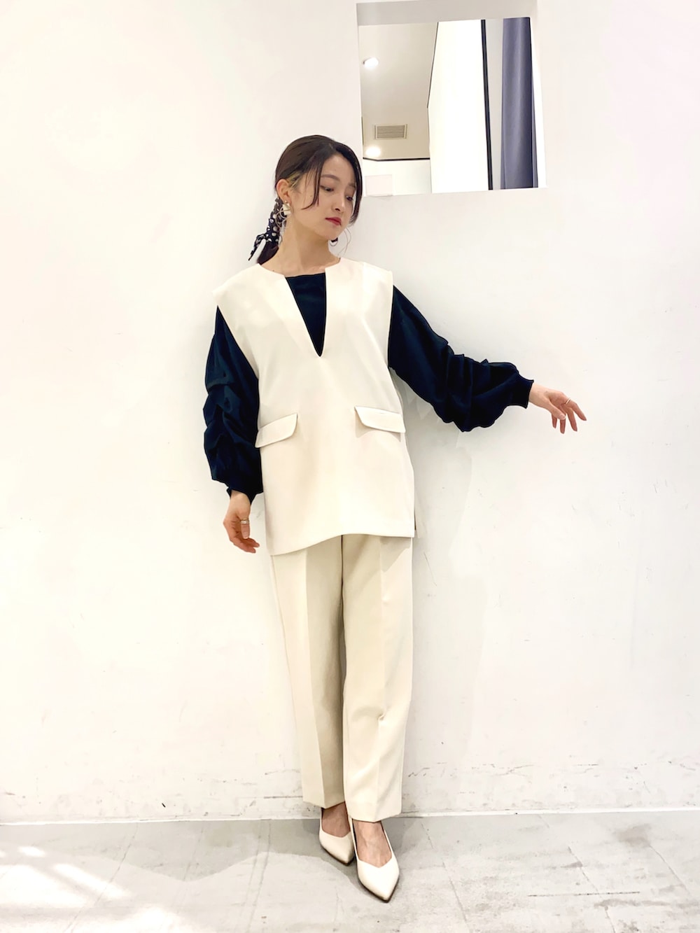 ブラック系のシャツ/ブラウス、ホワイト系のパンプス、ブルー系のトップスを着用したレディースの春コーディネートの3枚目の写真