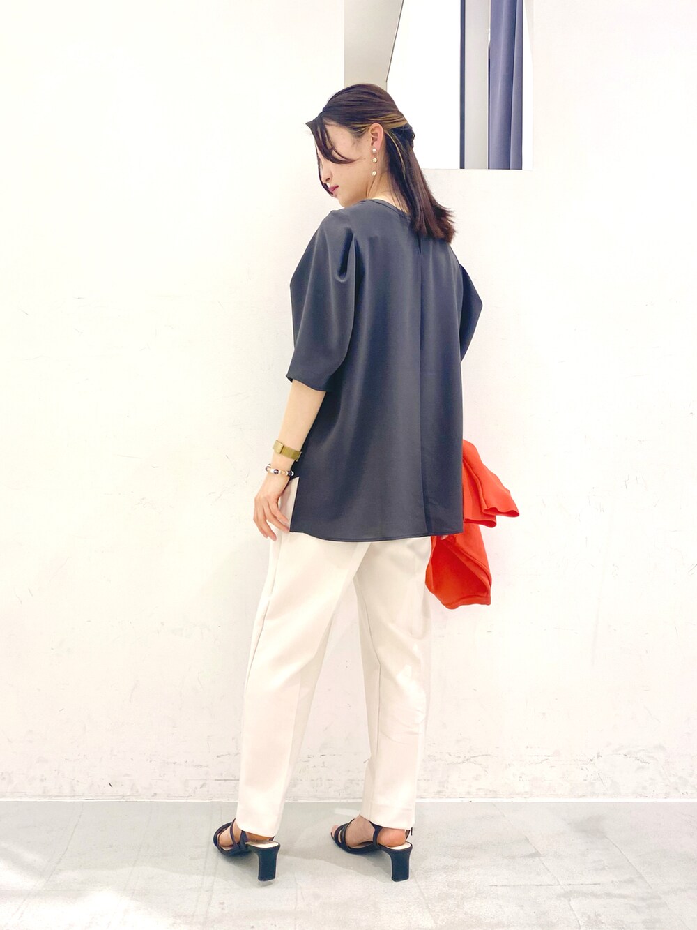 グレー系のトップス、オレンジ系のカーディガン/ボレロ、ベージュ系のその他パンツを着用したレディースの春コーディネートの4枚目の写真