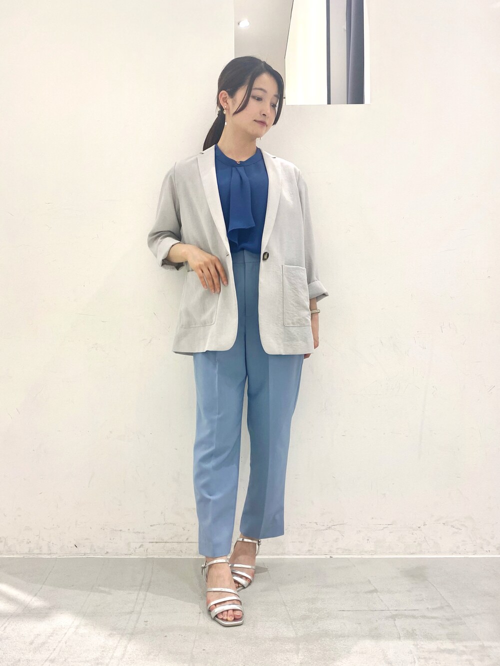 ブルー系のシャツ/ブラウス、グレー系のテーラードジャケット、シルバー系のサンダルを着用したレディースの春コーディネートの2枚目の写真