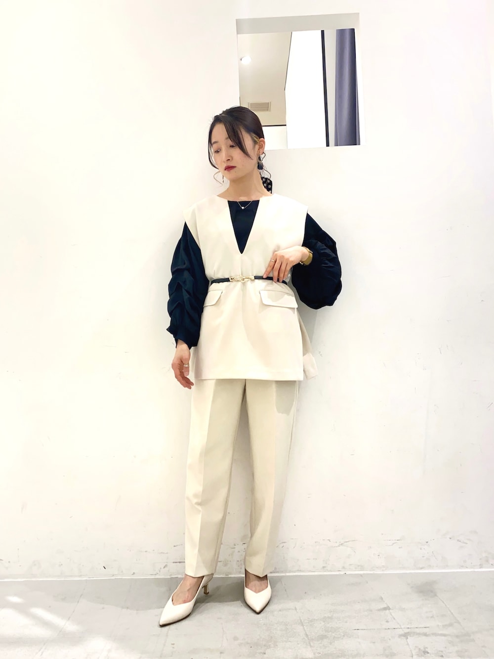 ブラック系のシャツ/ブラウス、ホワイト系のパンプス、ブルー系のトップスを着用したレディースの春コーディネートの2枚目の写真