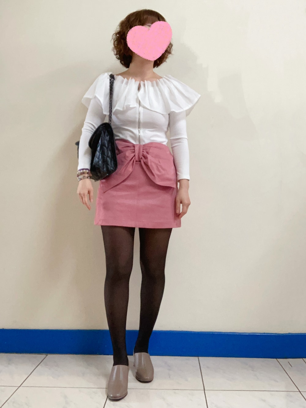 ブラウン系のブーティ、ブラック系のショルダーバッグ、ホワイト系のトップスを着用したレディースの春コーディネートの3枚目の写真