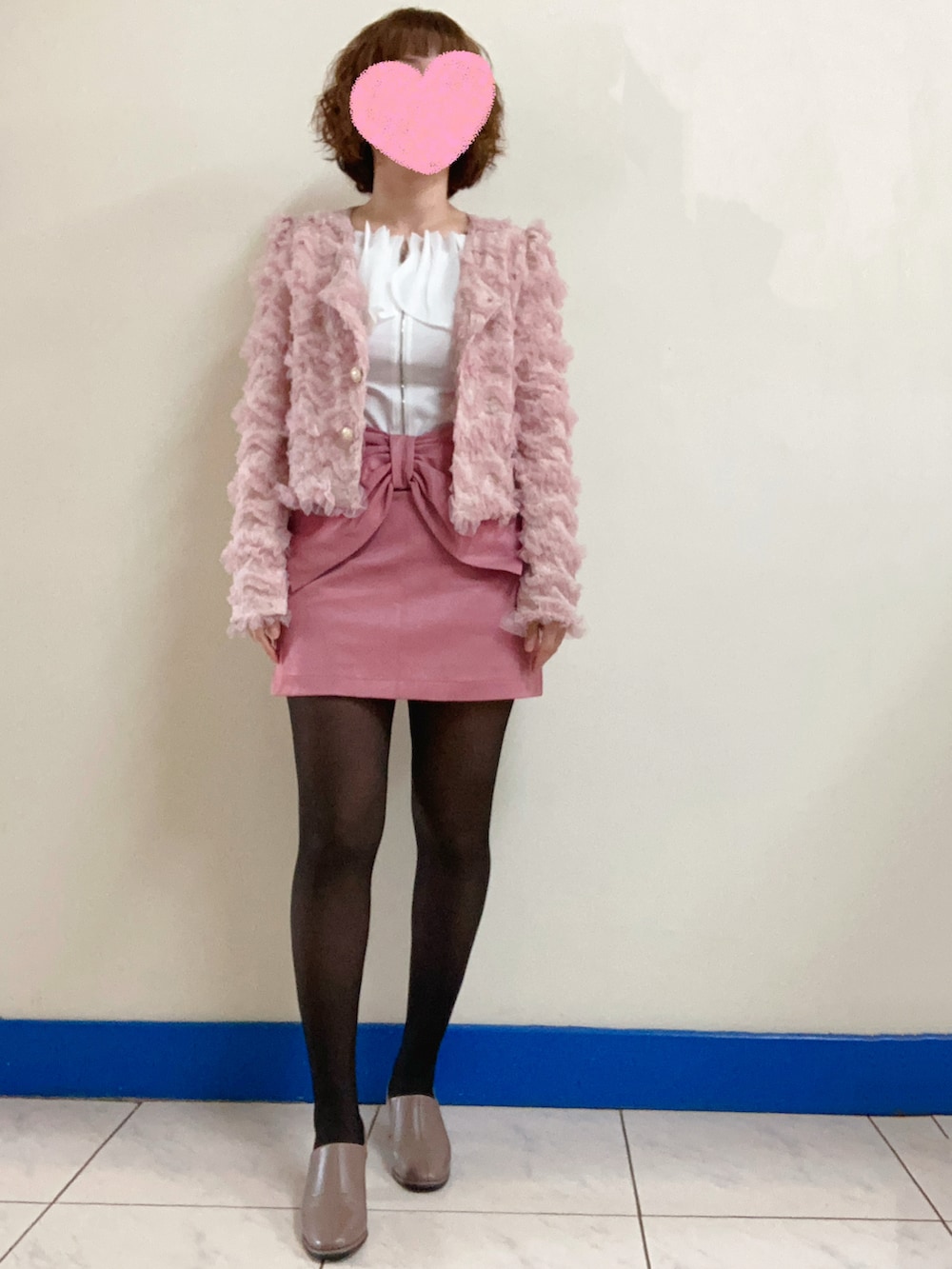 ブラウン系のブーティ、ブラック系のショルダーバッグ、ホワイト系のトップスを着用したレディースの春コーディネートの2枚目の写真