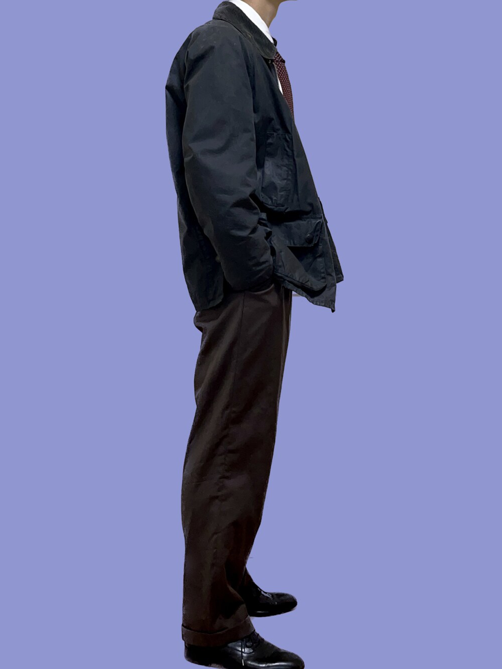 ブラック系のその他アウター、ブラウン系のスラックスを着用したメンズの冬コーディネートの2枚目の写真