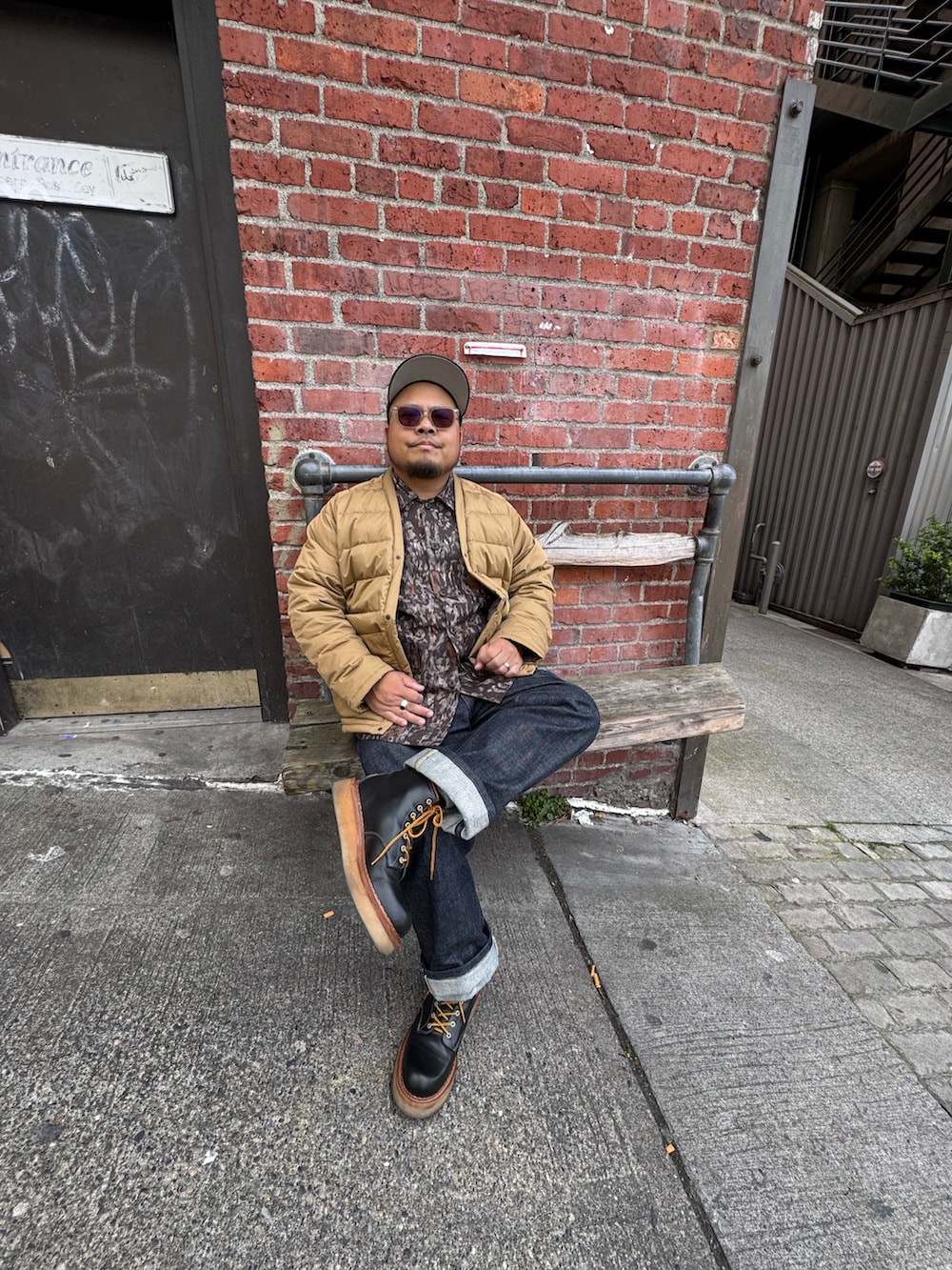 ブルー系のデニムパンツ、ブラック系のブーツ、ブラウン系のシャツ/ブラウスを着用したメンズの春コーディネートの3枚目の写真