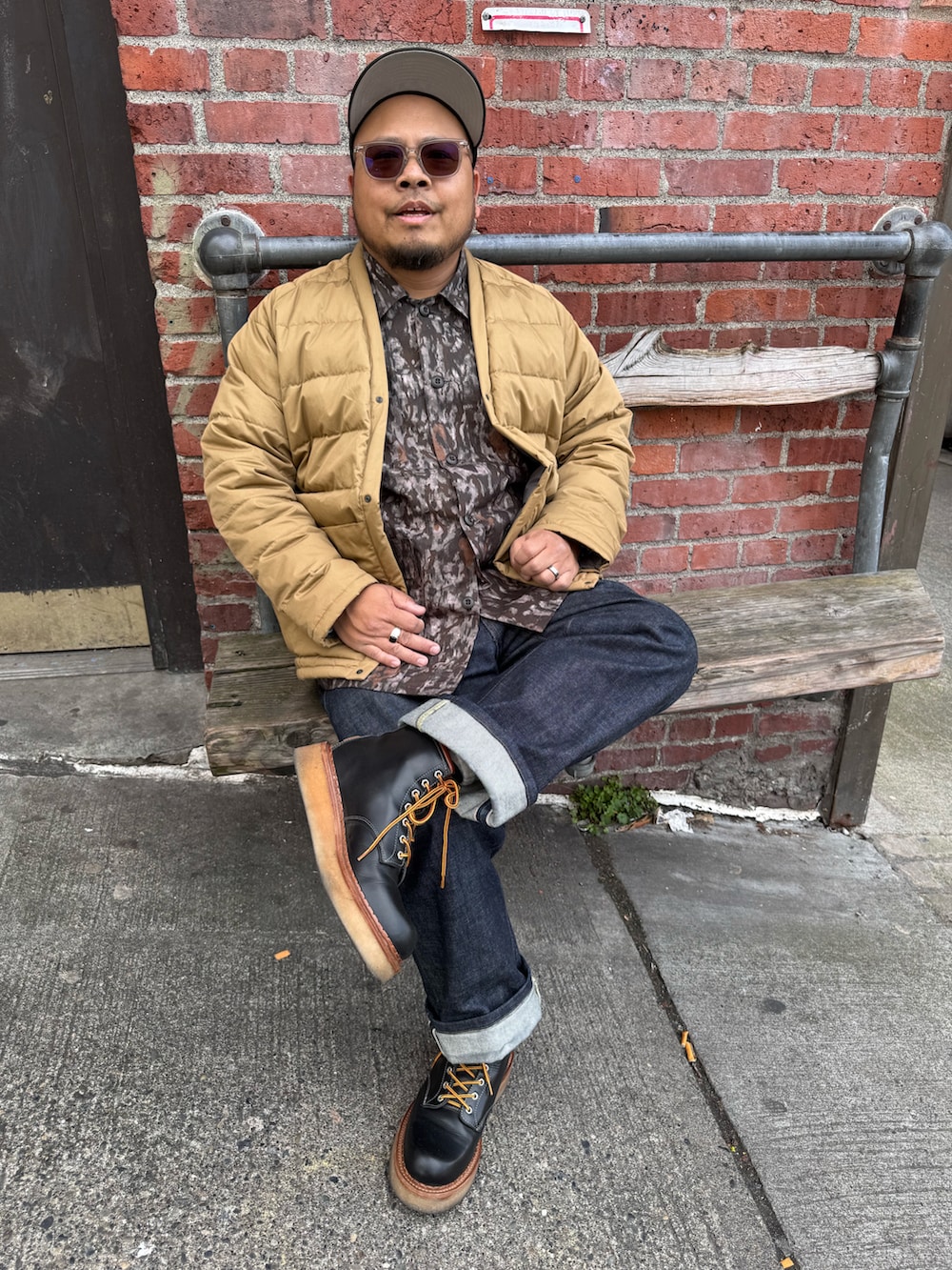 ブルー系のデニムパンツ、ブラック系のブーツ、ブラウン系のシャツ/ブラウスを着用したメンズの春コーディネートの2枚目の写真