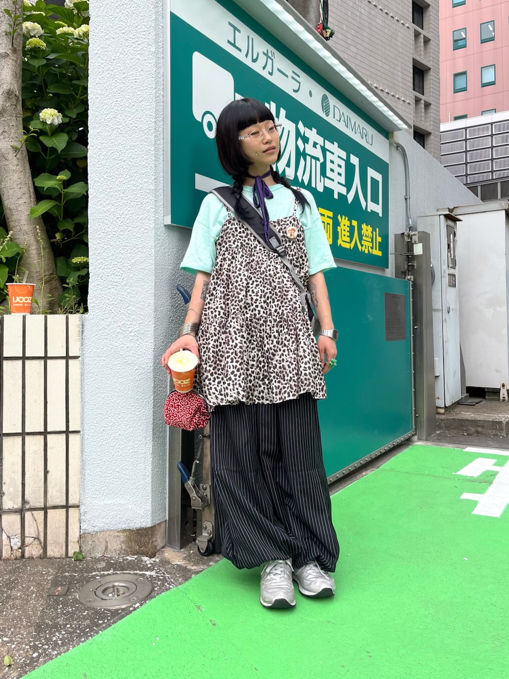 ブラック系のスラックス、ブラウン系のオールインワン・サロペット、シルバー系のスニーカーを着用したレディースの春コーディネートの3枚目の写真