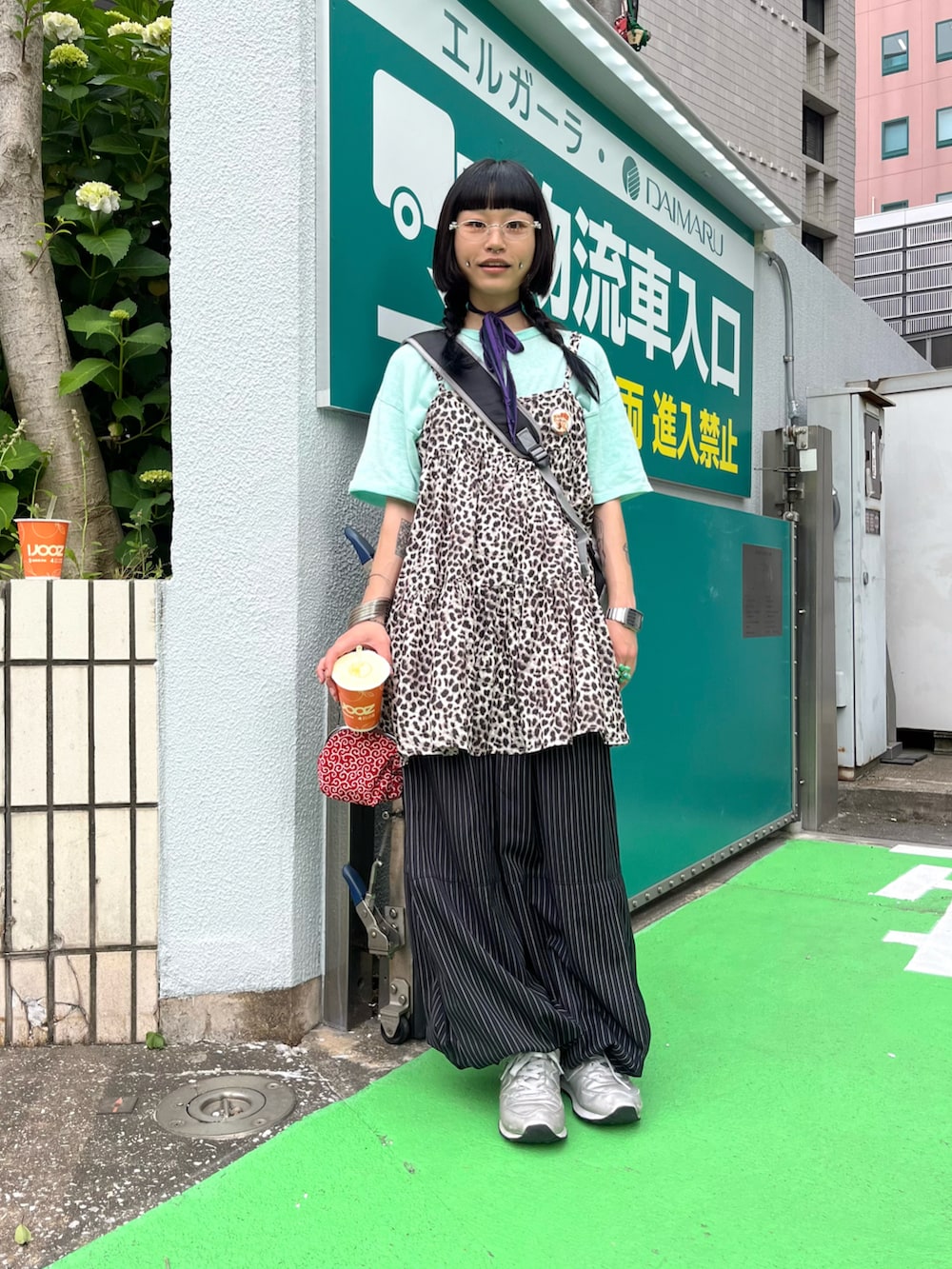 ブラック系のスラックス、ブラウン系のオールインワン・サロペット、シルバー系のスニーカーを着用したレディースの春コーディネートの2枚目の写真