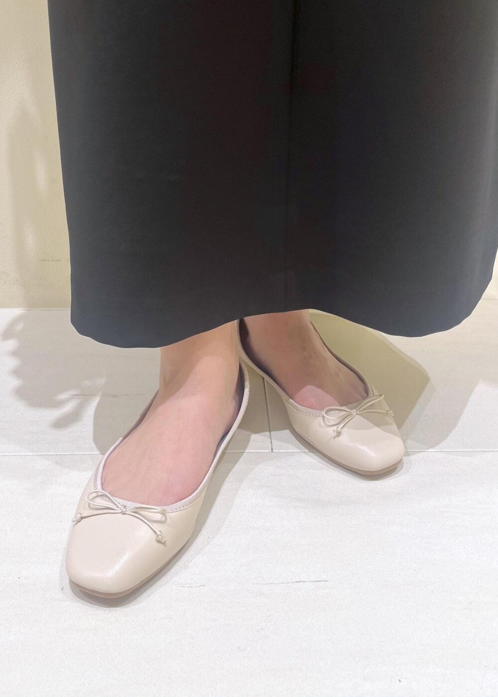 ホワイト系のバレエシューズ、ブラウン系のシャツ/ブラウス、ブラック系のジャンパースカートを着用したレディースの春コーディネートの10枚目の写真