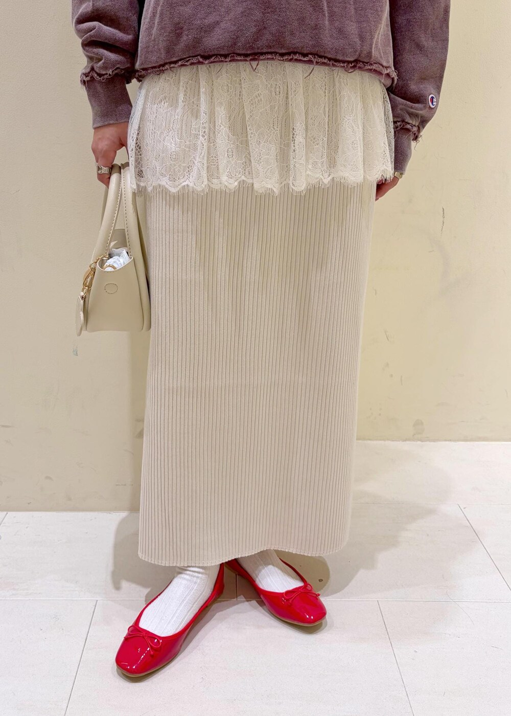 レッド系のバレエシューズ、ホワイト系のショルダーバッグ、ホワイト系のキャミソールを着用したレディースの冬コーディネートの7枚目の写真