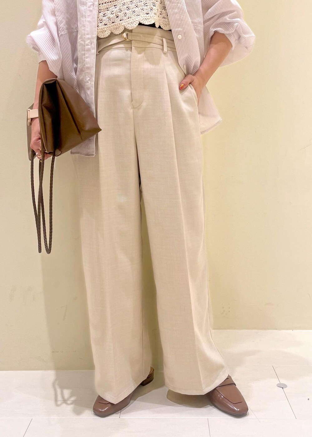 ブラック系のタンクトップ、ブラウン系のトートバッグ、イエロー系のローファーを着用したレディースの春コーディネートの9枚目の写真