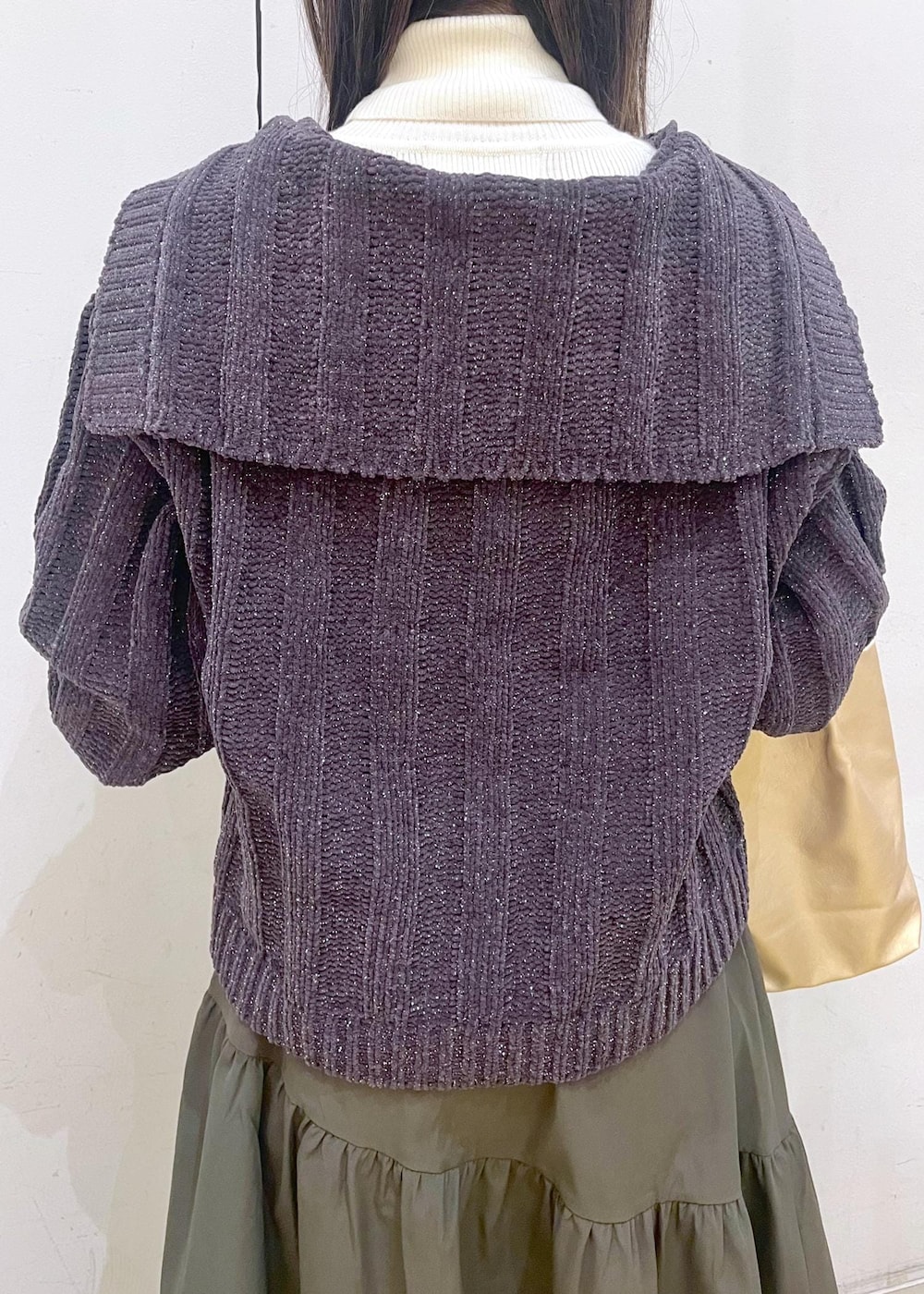 ホワイト系のニット/セーター、ブラック系のバレエシューズ、グリーン系のスカートを着用したレディースの冬コーディネートの6枚目の写真