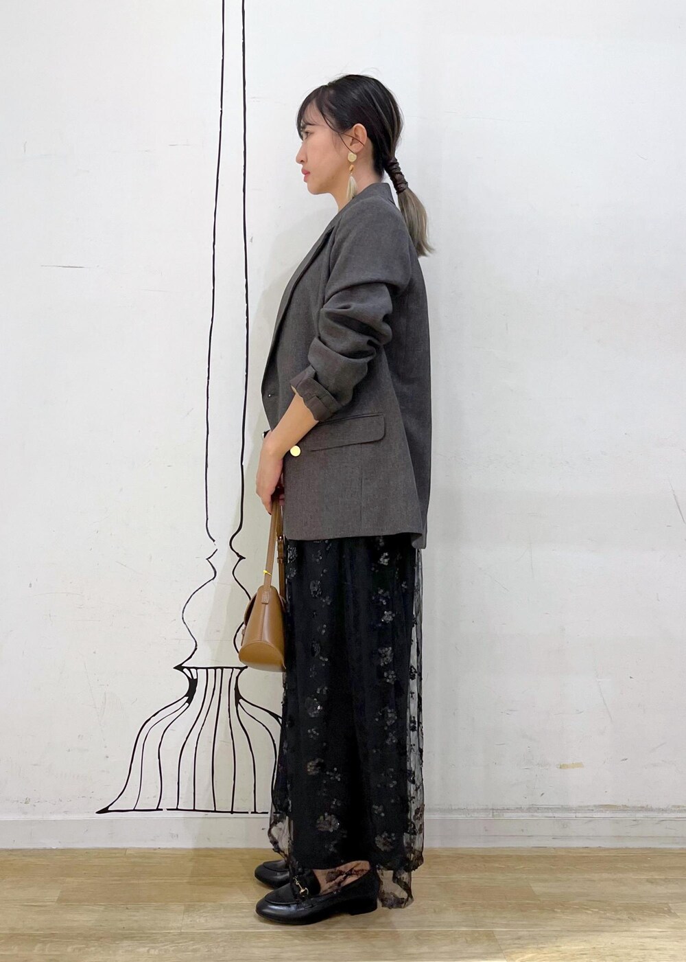 ブラック系のスカート、ベージュ系のTシャツ/カットソー、ブラウン系のテーラードジャケットを着用したレディースの秋コーディネートの4枚目の写真