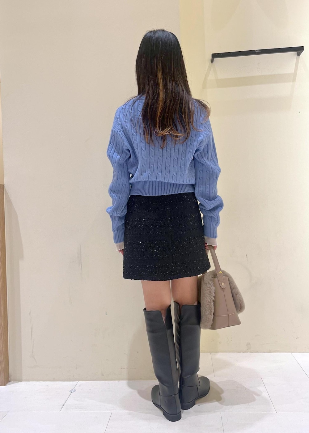 ブルー系のスカート、ホワイト系のTシャツ/カットソー、ブルー系のニット/セーターを着用したレディースの冬コーディネートの3枚目の写真