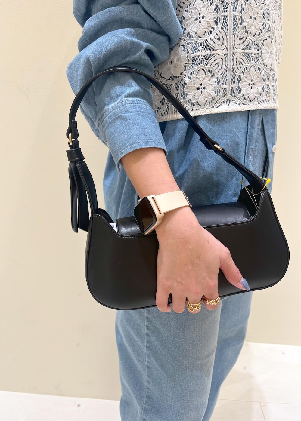 ブルー系のデニムパンツ、ホワイト系のキャミソール、ブラック系のハンドバッグを着用したレディースの春コーディネートの9枚目の写真