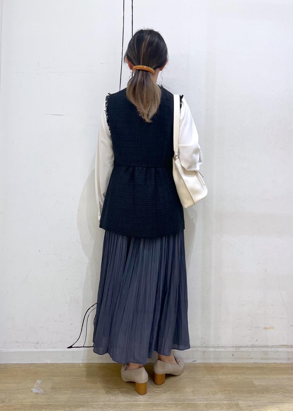 ブルー系のスカート、ベージュ系のローファー、ホワイト系のハンドバッグを着用したレディースの冬コーディネートの4枚目の写真