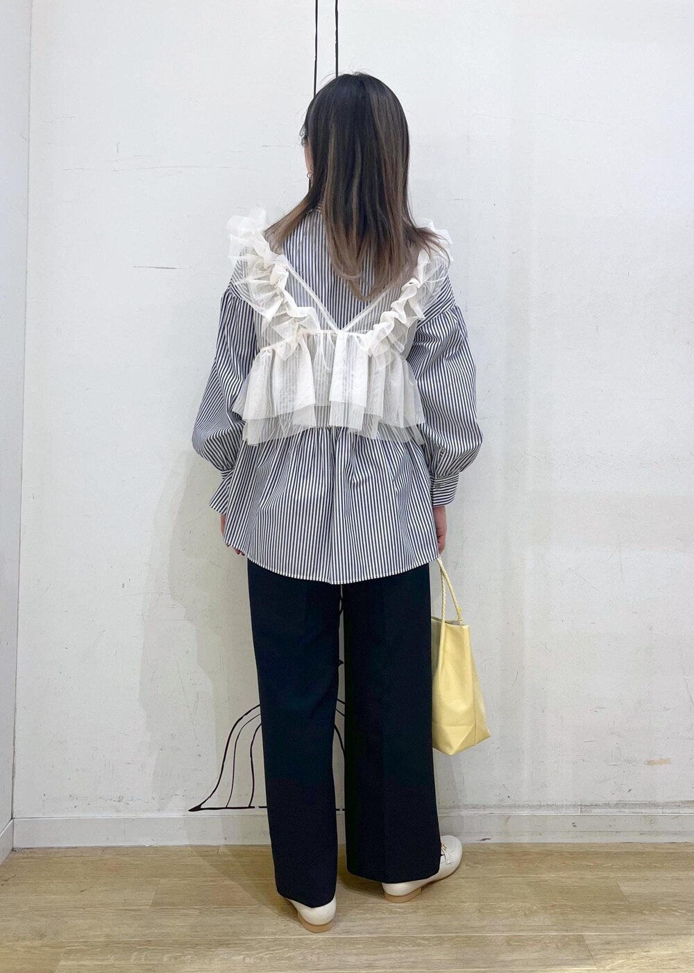 ホワイト系のベスト、ブルー系のその他パンツ、イエロー系のトートバッグを着用したレディースの冬コーディネートの4枚目の写真