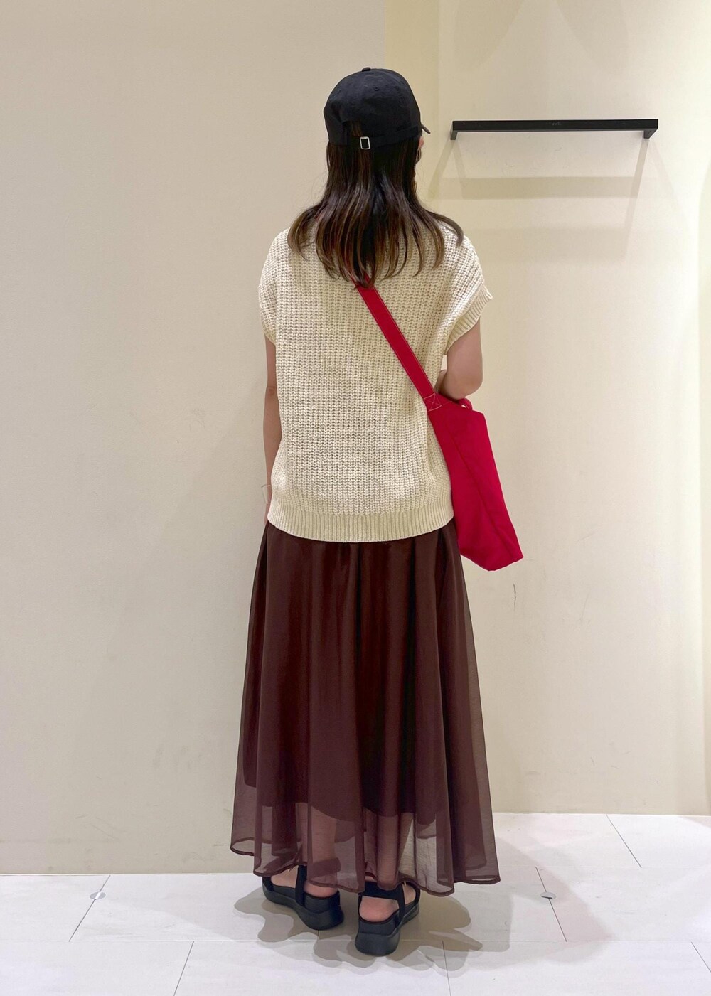 ブラック系のサンダル、ブラウン系のスカート、ベージュ系のベストを着用したレディースの夏コーディネートの4枚目の写真