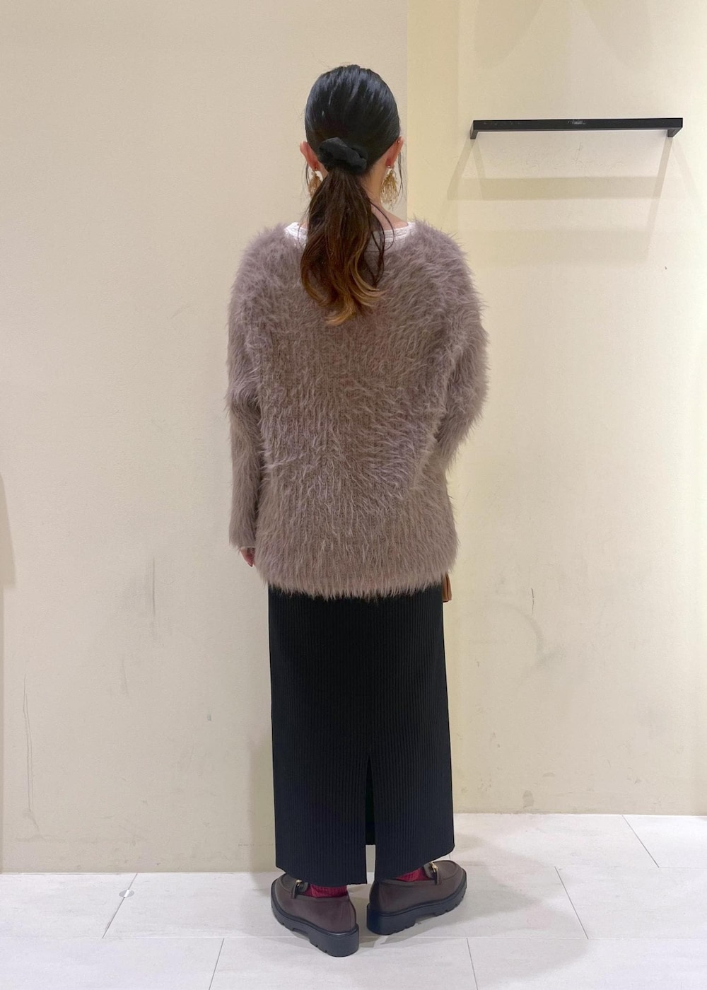 ホワイト系のTシャツ/カットソー、ブラウン系のニット/セーター、ブラウン系のローファーを着用したレディースの秋コーディネートの3枚目の写真