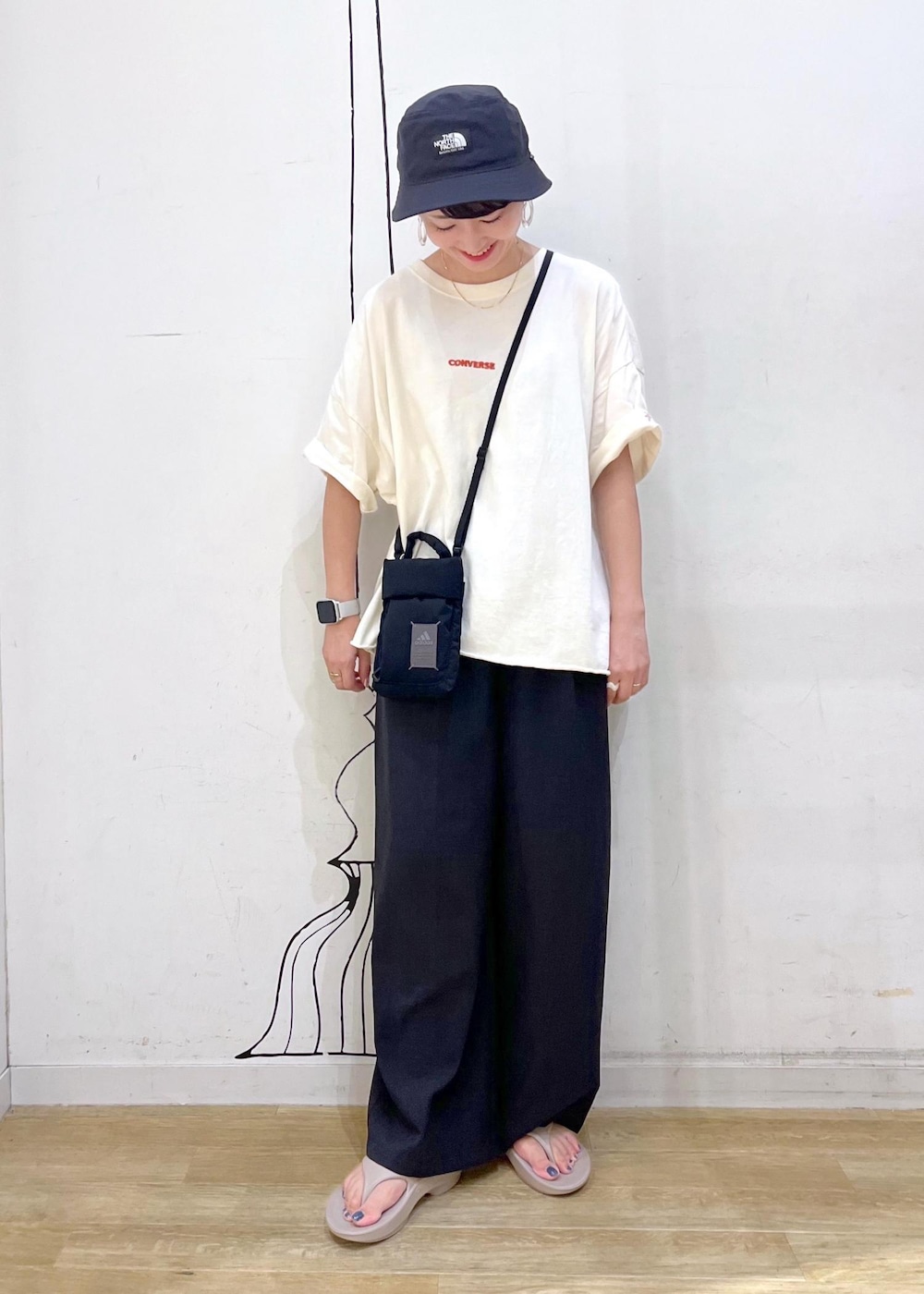 グレー系のその他パンツ、ホワイト系のTシャツ/カットソー、ブラック系のショルダーバッグを着用したレディースの夏コーディネートの2枚目の写真