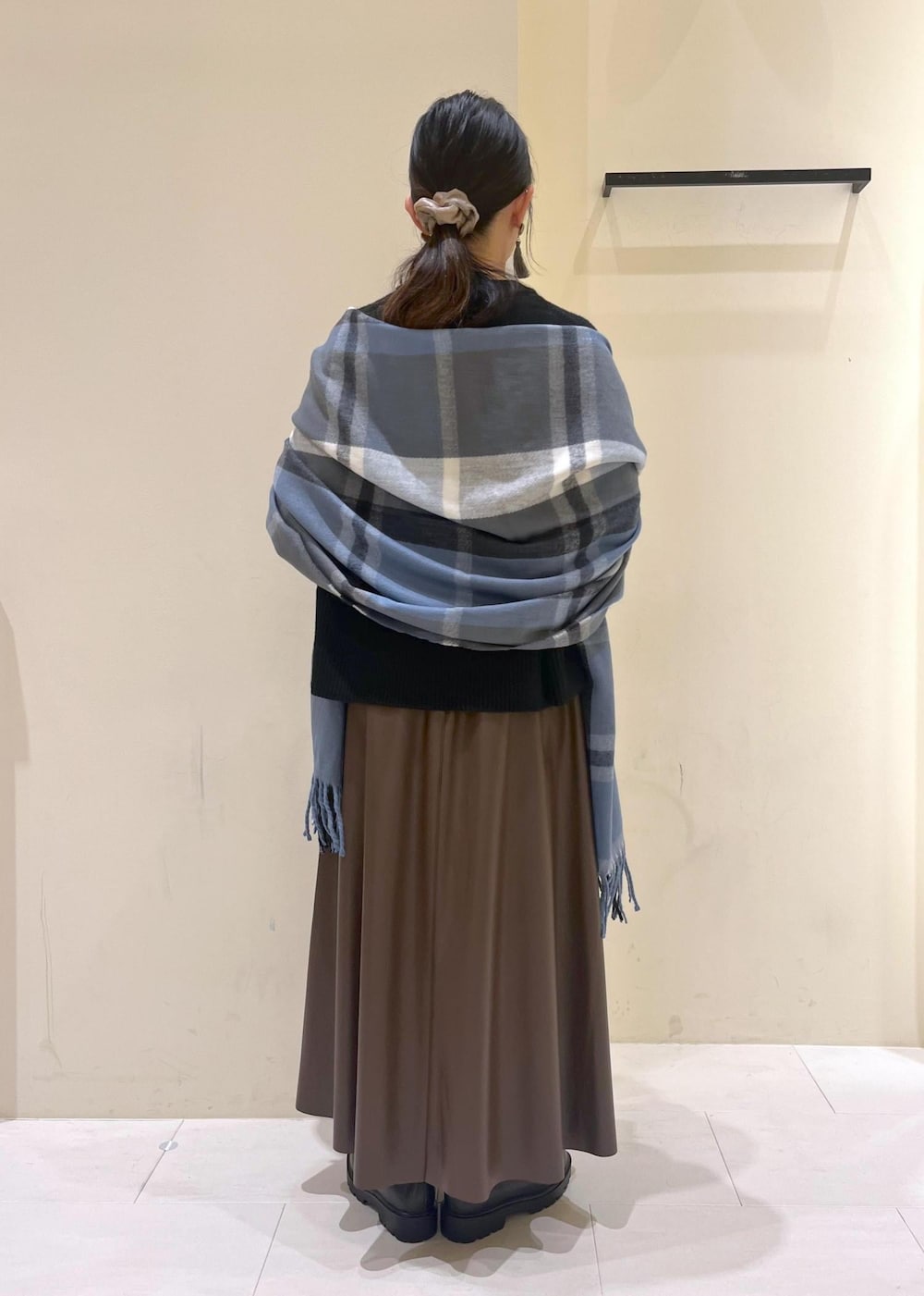 ブラウン系のスカート、ブラウン系のボストンバッグ、ブラック系のニット/セーターを着用したレディースの秋コーディネートの3枚目の写真