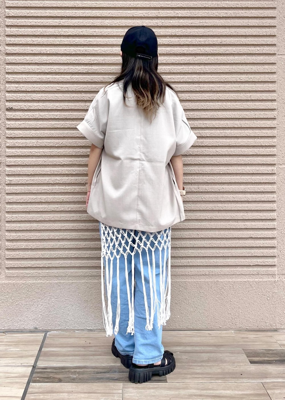 ブルー系のデニムパンツ、ホワイト系のスカート、ブラック系のTシャツ/カットソーを着用したレディースの春コーディネートの5枚目の写真