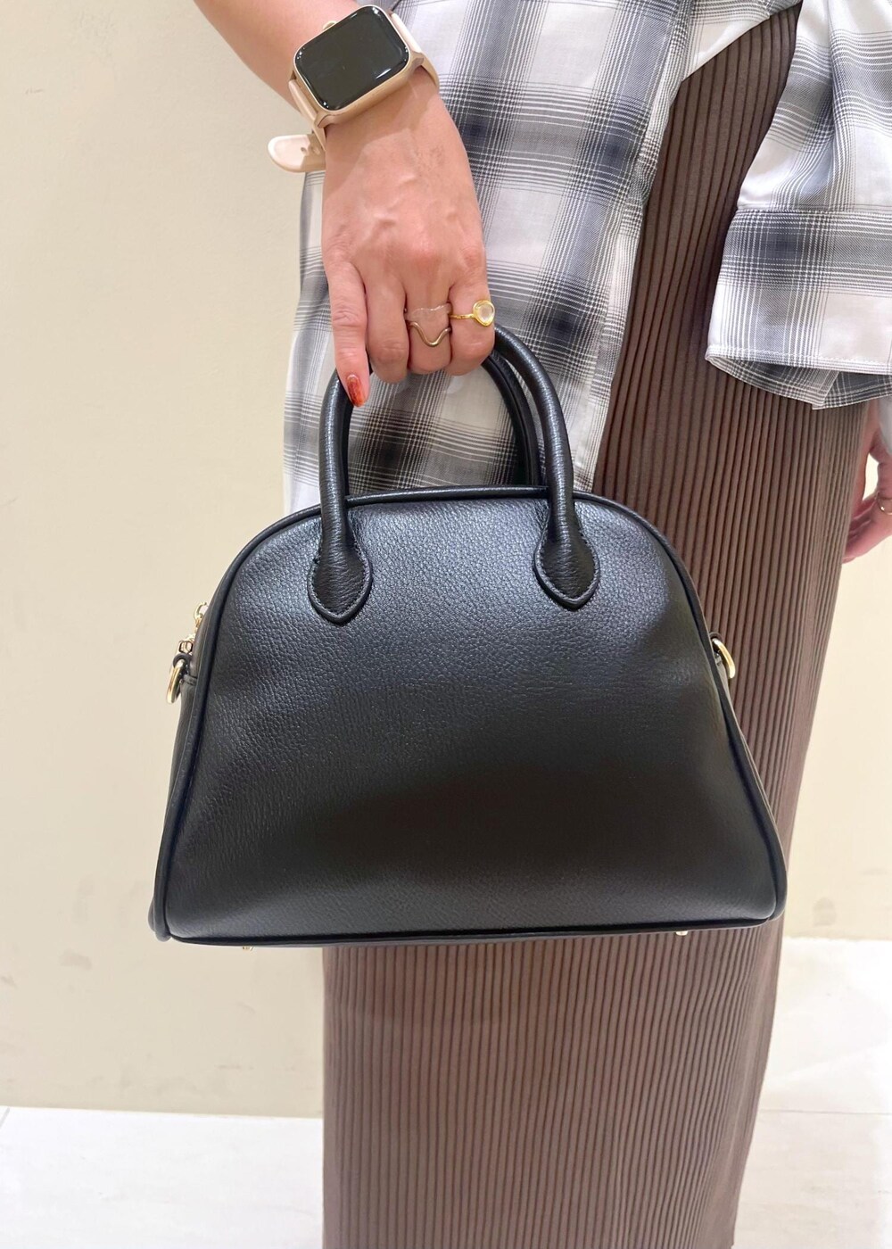 ブラック系のスカート、ブラック系のボストンバッグ、ブラック系のポロシャツを着用したレディースの夏コーディネートの9枚目の写真