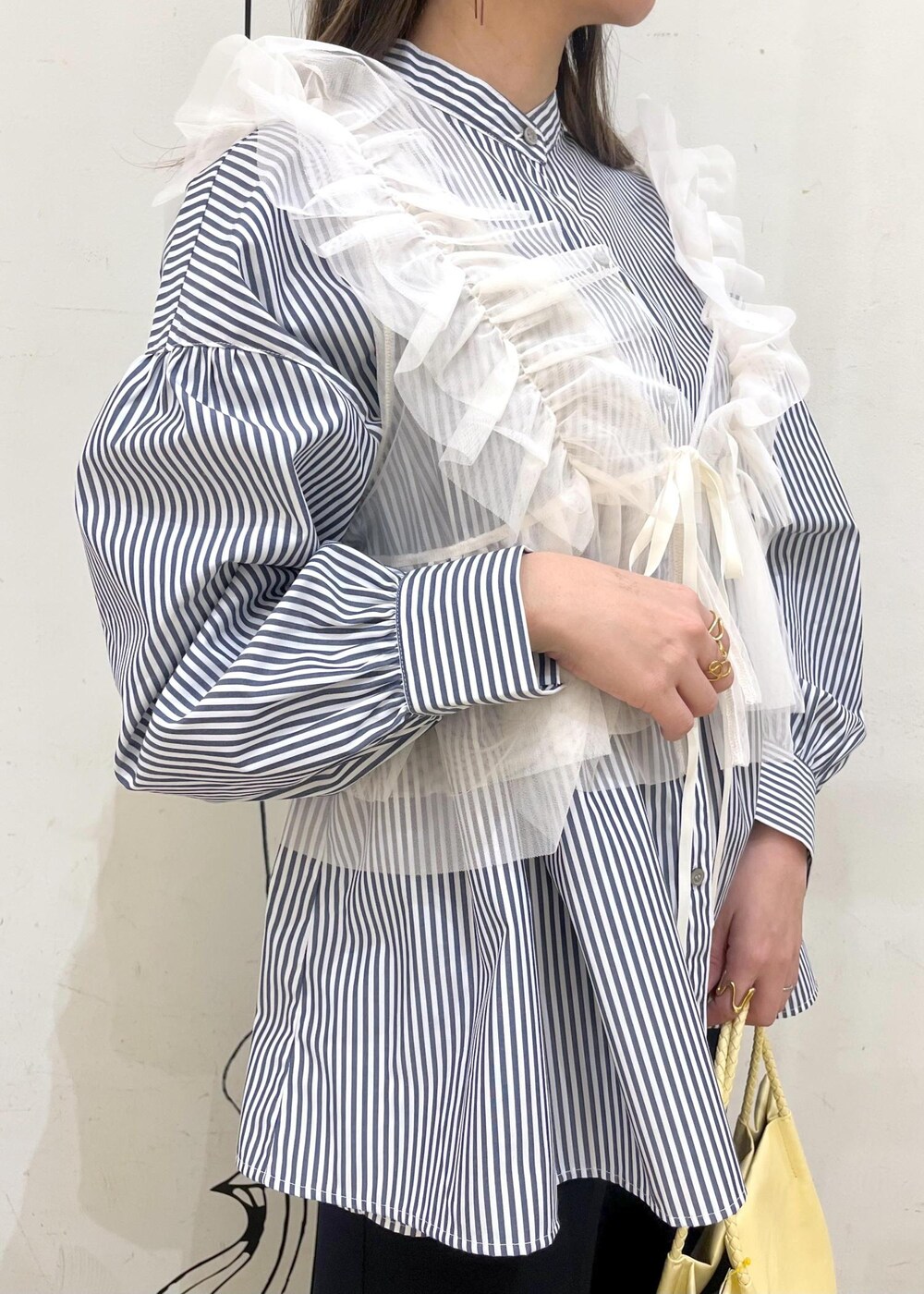 ホワイト系のベスト、ブルー系のその他パンツ、イエロー系のトートバッグを着用したレディースの冬コーディネートの5枚目の写真