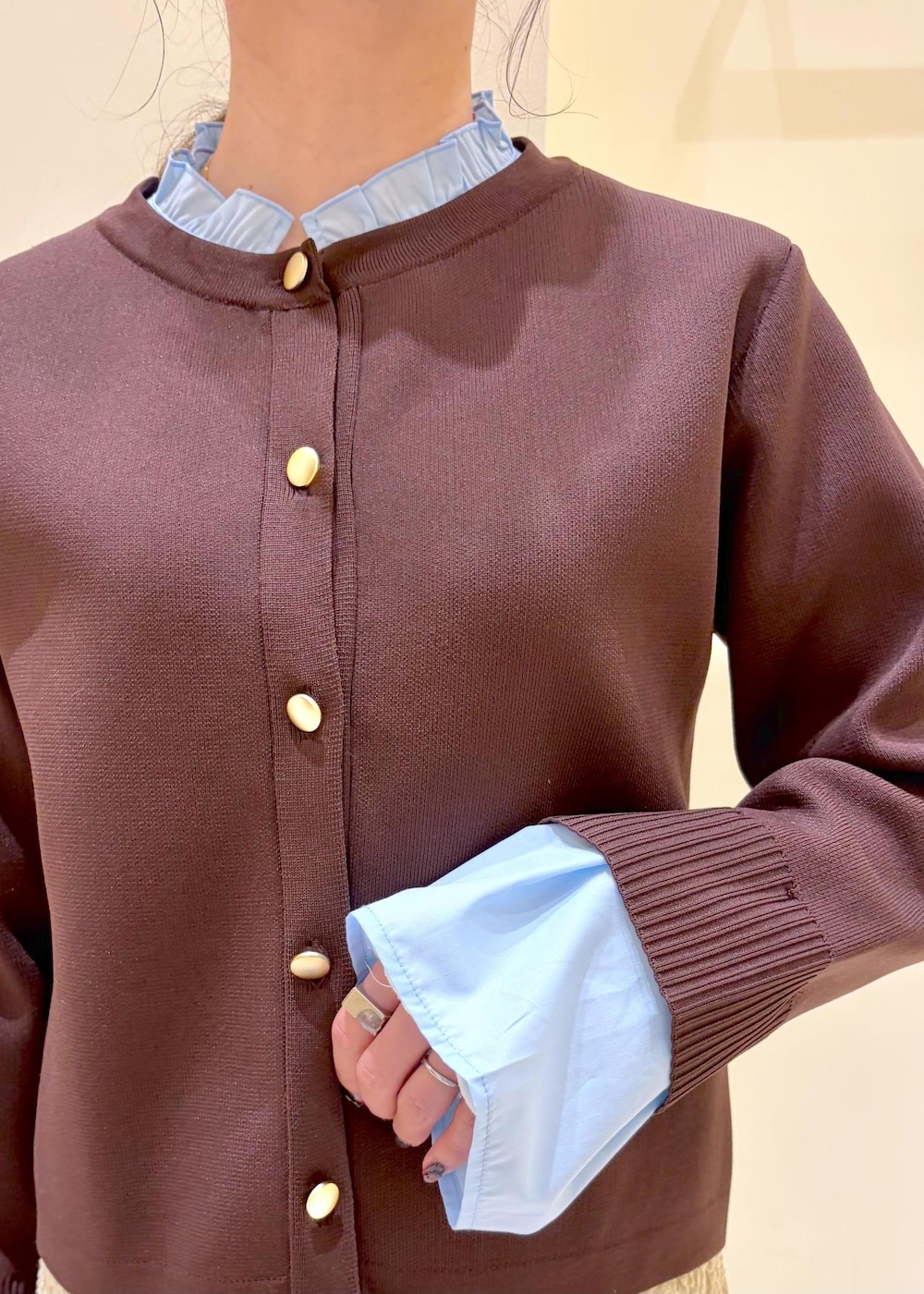 ホワイト系のボストンバッグ、ベージュ系のスカート、ブラウン系のカーディガン/ボレロを着用したレディースの春コーディネートの5枚目の写真