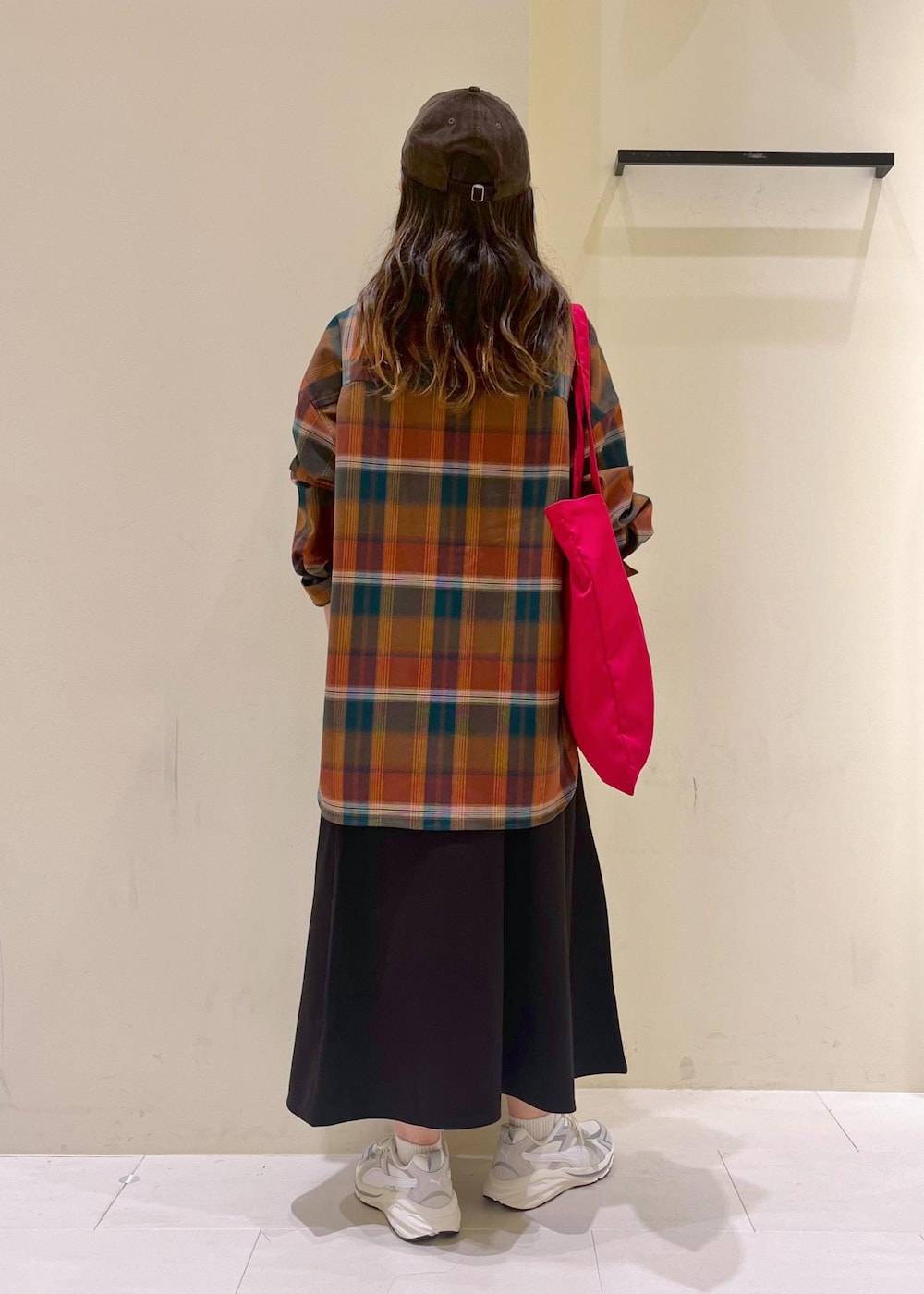 ブラック系のスカート、オレンジ系のシャツ/ブラウス、レッド系のトートバッグを着用したレディースの秋コーディネートの3枚目の写真