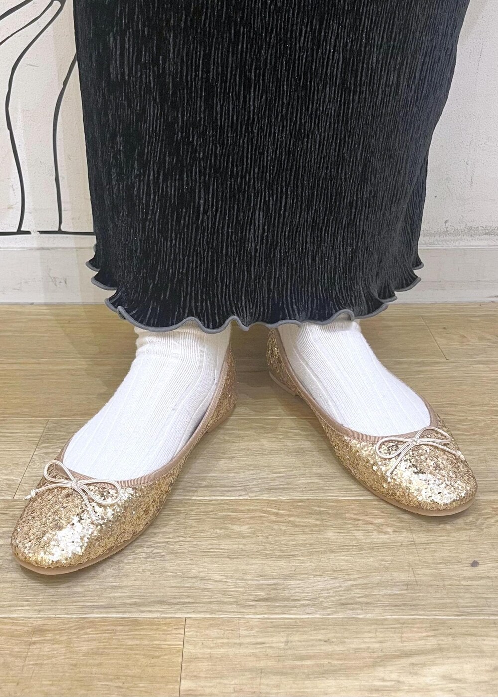 ホワイト系のトートバッグ、ブラック系のニット/セーター、ゴールド系のバレエシューズを着用したレディースの冬コーディネートの10枚目の写真