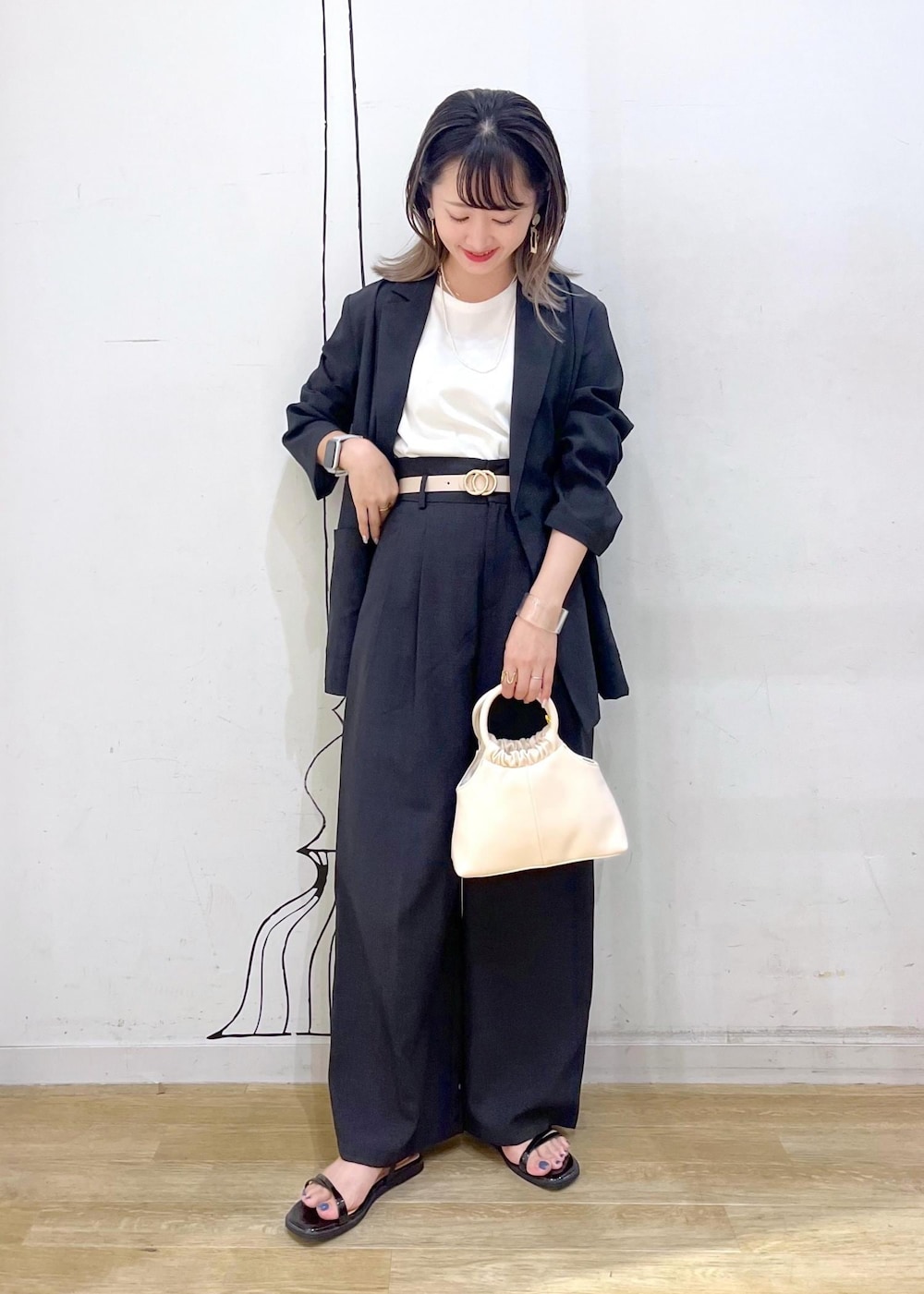 ブラック系のサンダル、グレー系のその他パンツ、ホワイト系のTシャツ/カットソーを着用したレディースの夏コーディネートの2枚目の写真