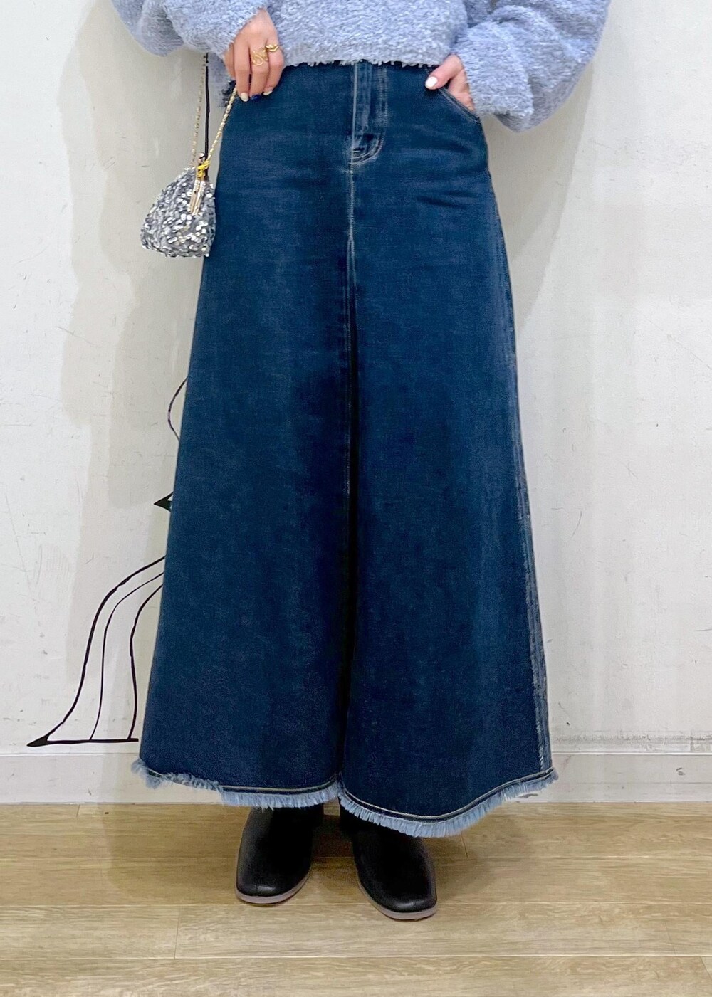 ブラック系のブーツ、グレー系のショルダーバッグ、ブルー系のデニムスカートを着用したレディースの冬コーディネートの7枚目の写真