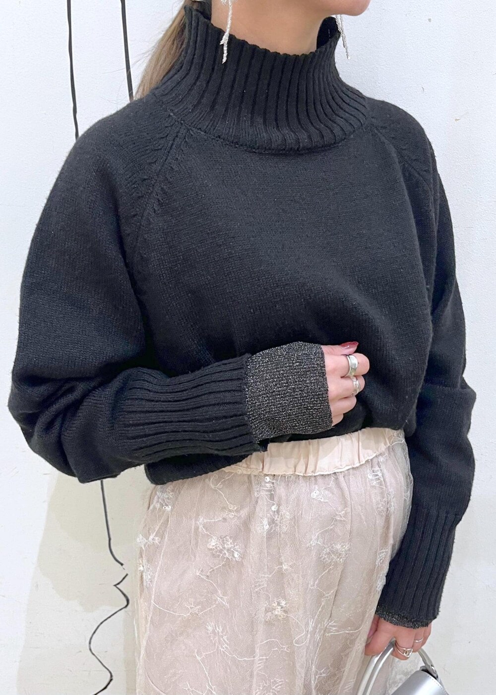 ブラック系のニット/セーター、ホワイト系のスカート、ブラック系のパンプスを着用したレディースの冬コーディネートの5枚目の写真