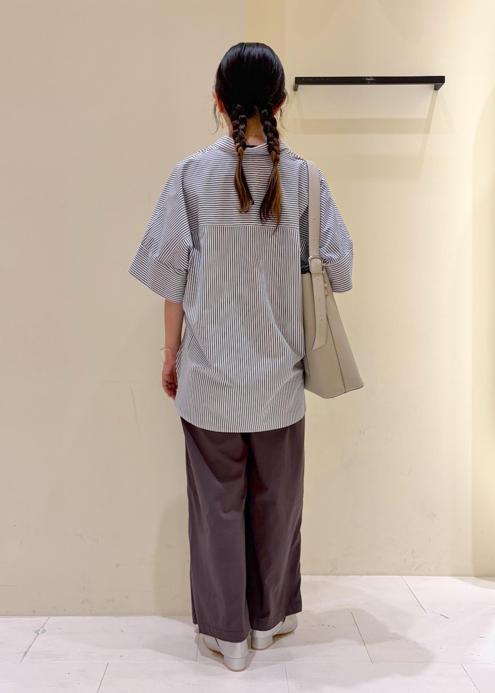 ブルー系のシャツ/ブラウス、ブラック系のニット/セーター、グレー系のその他パンツを着用したレディースの春コーディネートの3枚目の写真