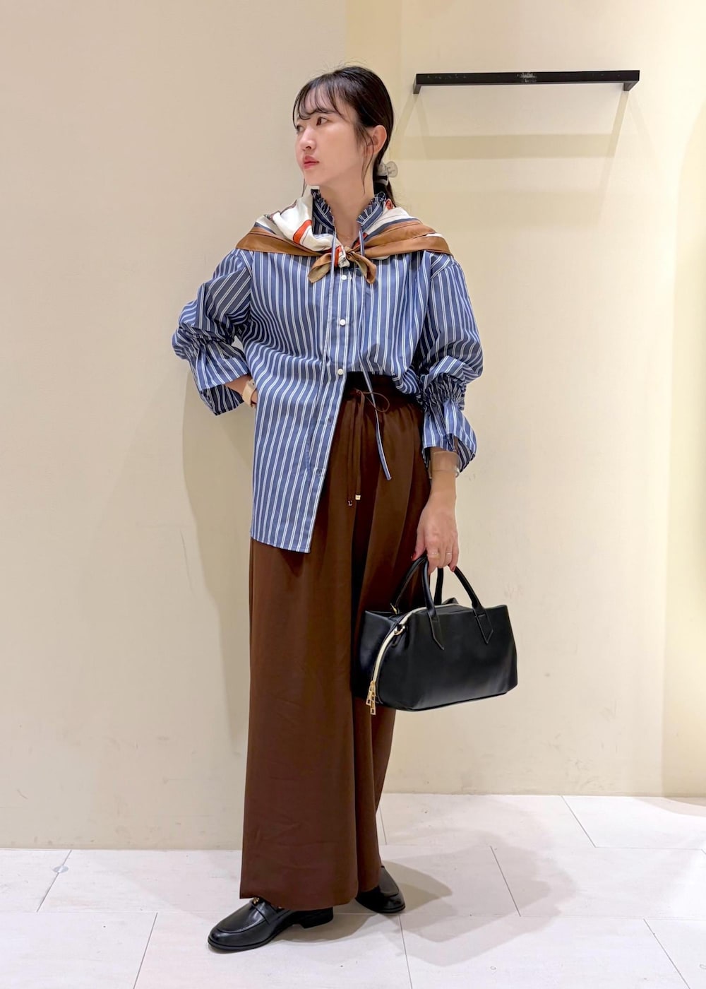 ブラウン系のその他パンツ、ブルー系のシャツ/ブラウス、ブラック系のローファーを着用したレディースの秋コーディネートの2枚目の写真