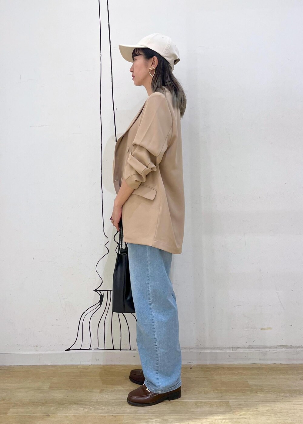 ブラウン系のローファー、ブラック系のトートバッグ、ブルー系のデニムパンツを着用したレディースの秋コーディネートの4枚目の写真