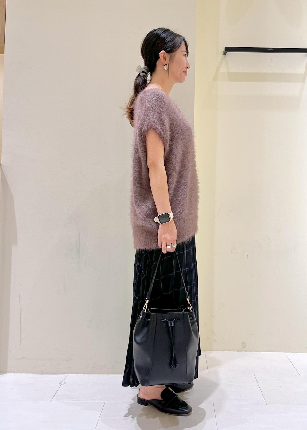 グレー系のタンクトップ、ブラック系のローファー、ブラック系のショルダーバッグを着用したレディースの夏コーディネートの3枚目の写真