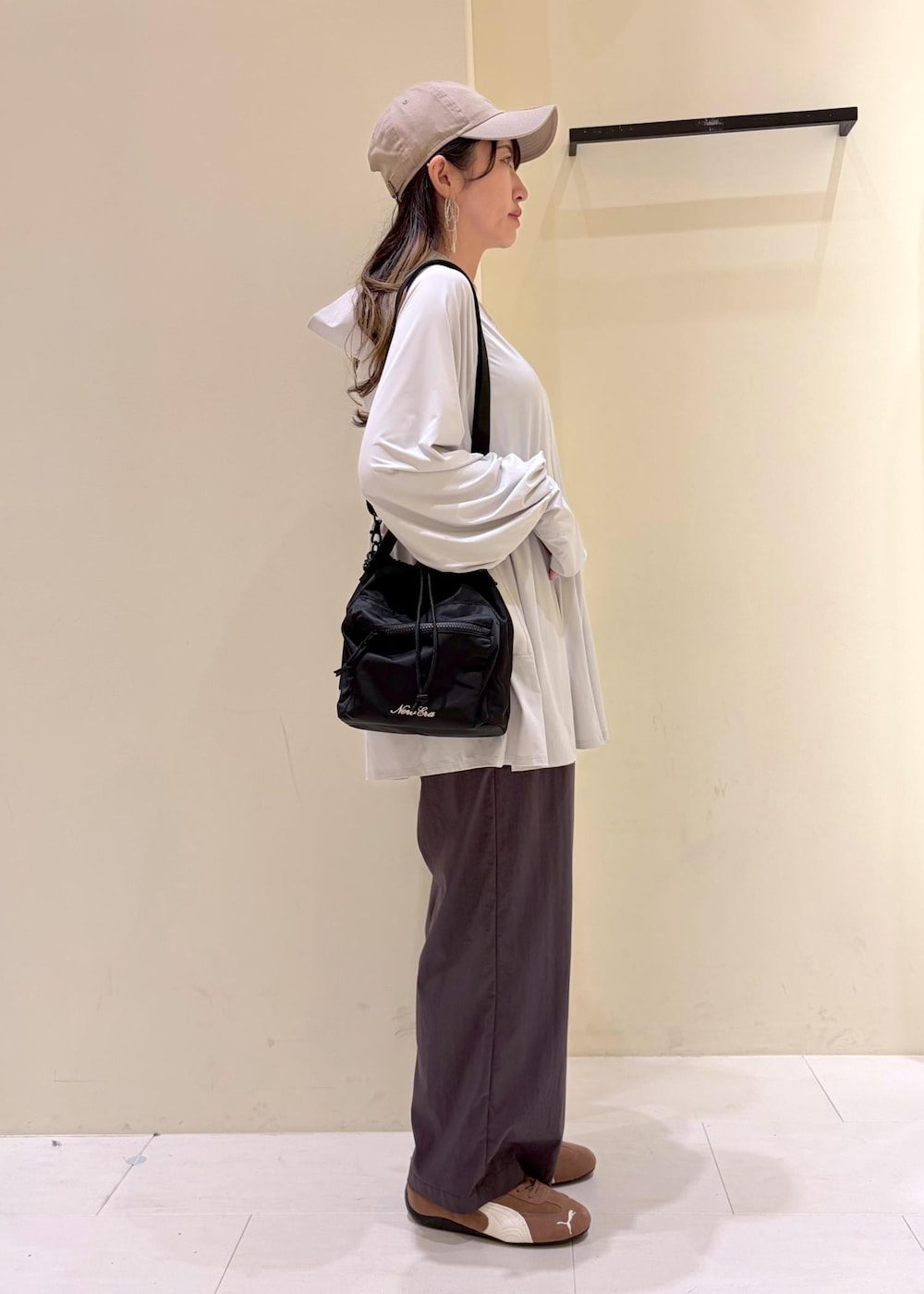 グレー系のパーカー、グレー系のその他パンツ、ブラック系のショルダーバッグを着用したレディースの春コーディネートの2枚目の写真