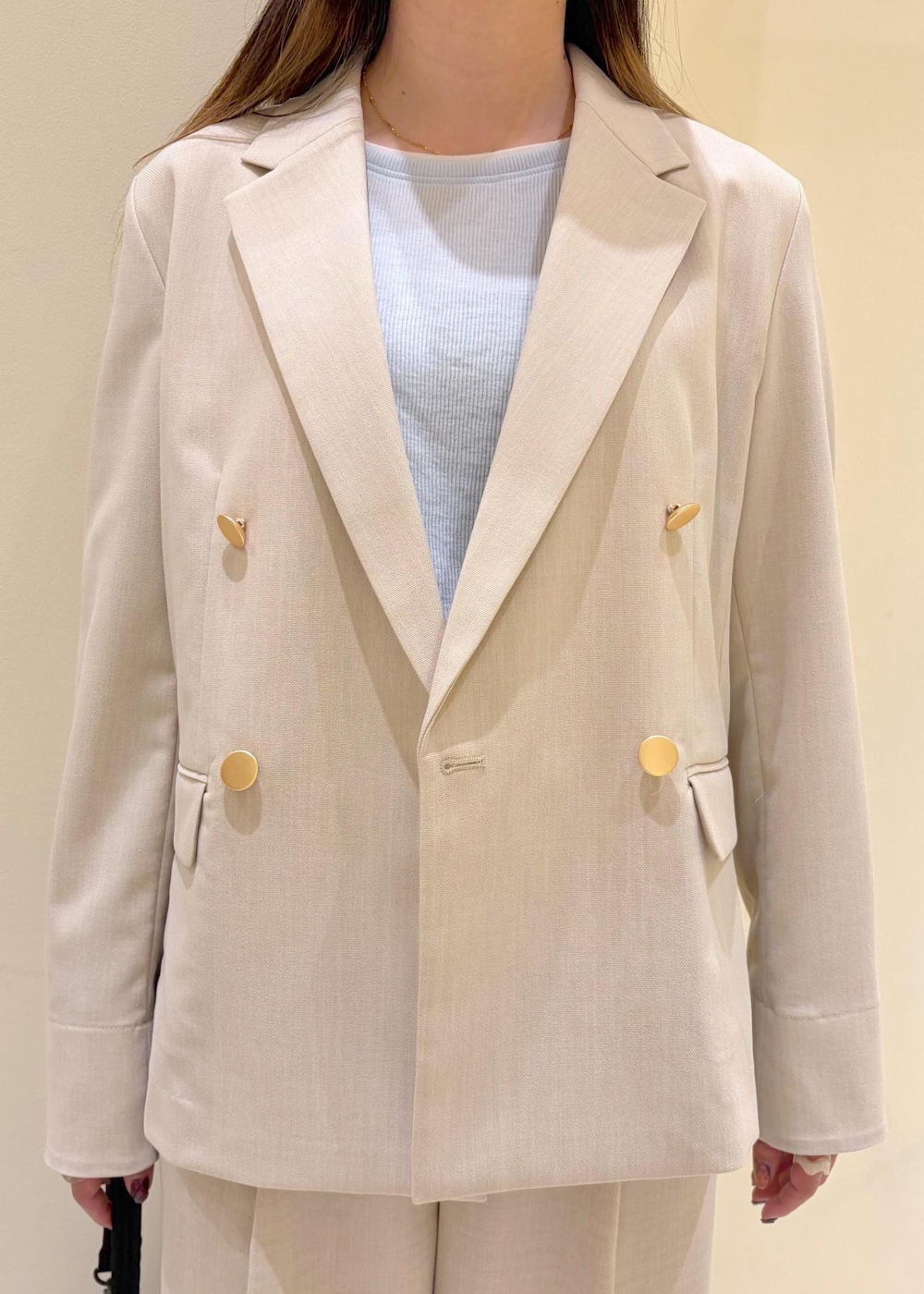 ベージュ系のその他パンツ、ベージュ系のテーラードジャケット、ブルー系のTシャツ/カットソーを着用したレディースの春コーディネートの5枚目の写真