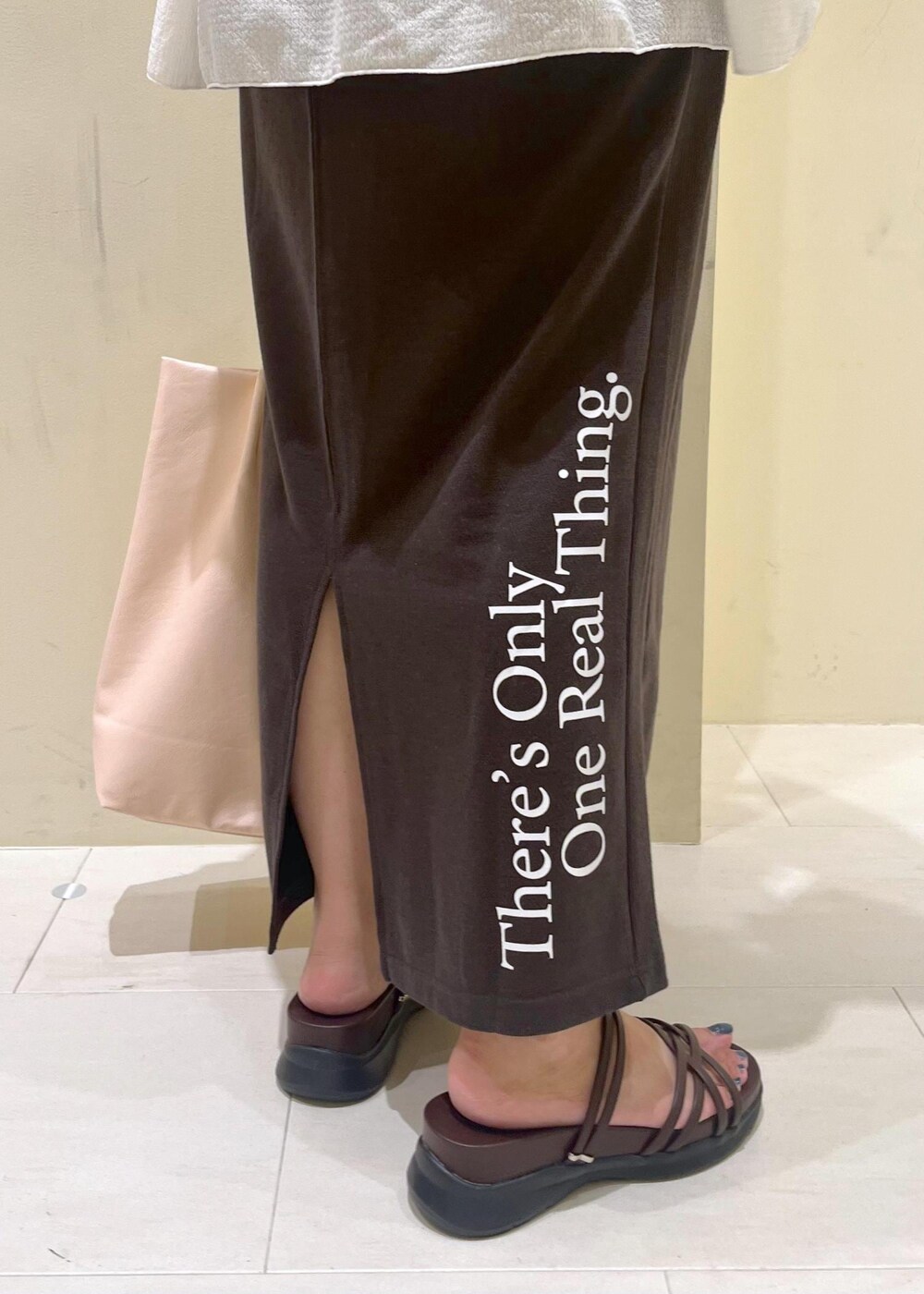 ピンク系のトートバッグ、ブラウン系のサンダル、ホワイト系のシャツ/ブラウスを着用したレディースの夏コーディネートの8枚目の写真